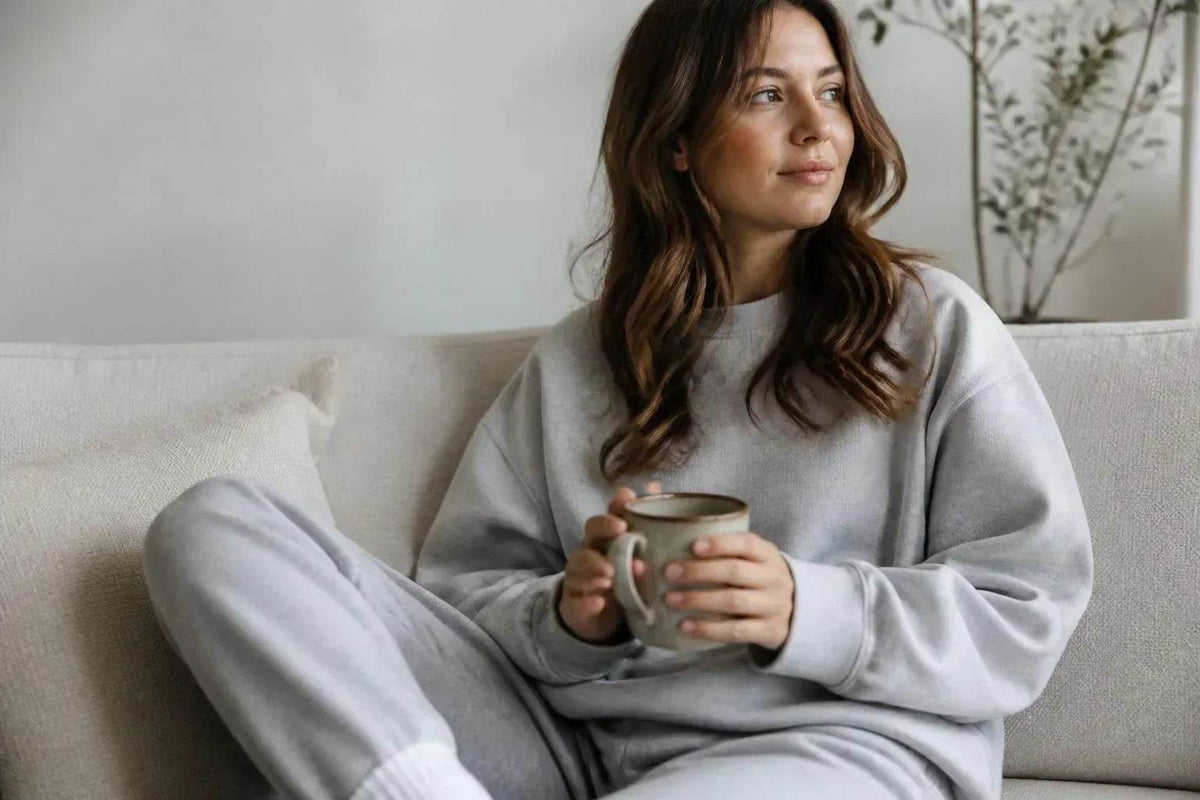 Cozy Sweatshirts, a light gray soft knit matching crewneck top and relaxed pants with ribbed cuffs and hem worn as loungewear