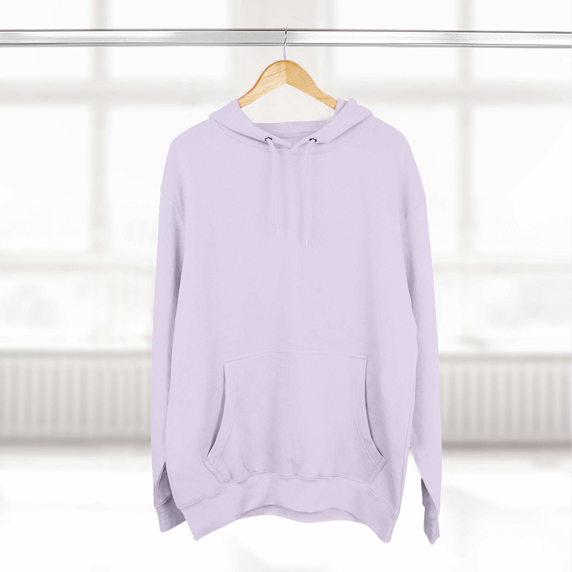 Pink fleece hoodie with adjustable hood and kangaroo pocket on wooden hanger