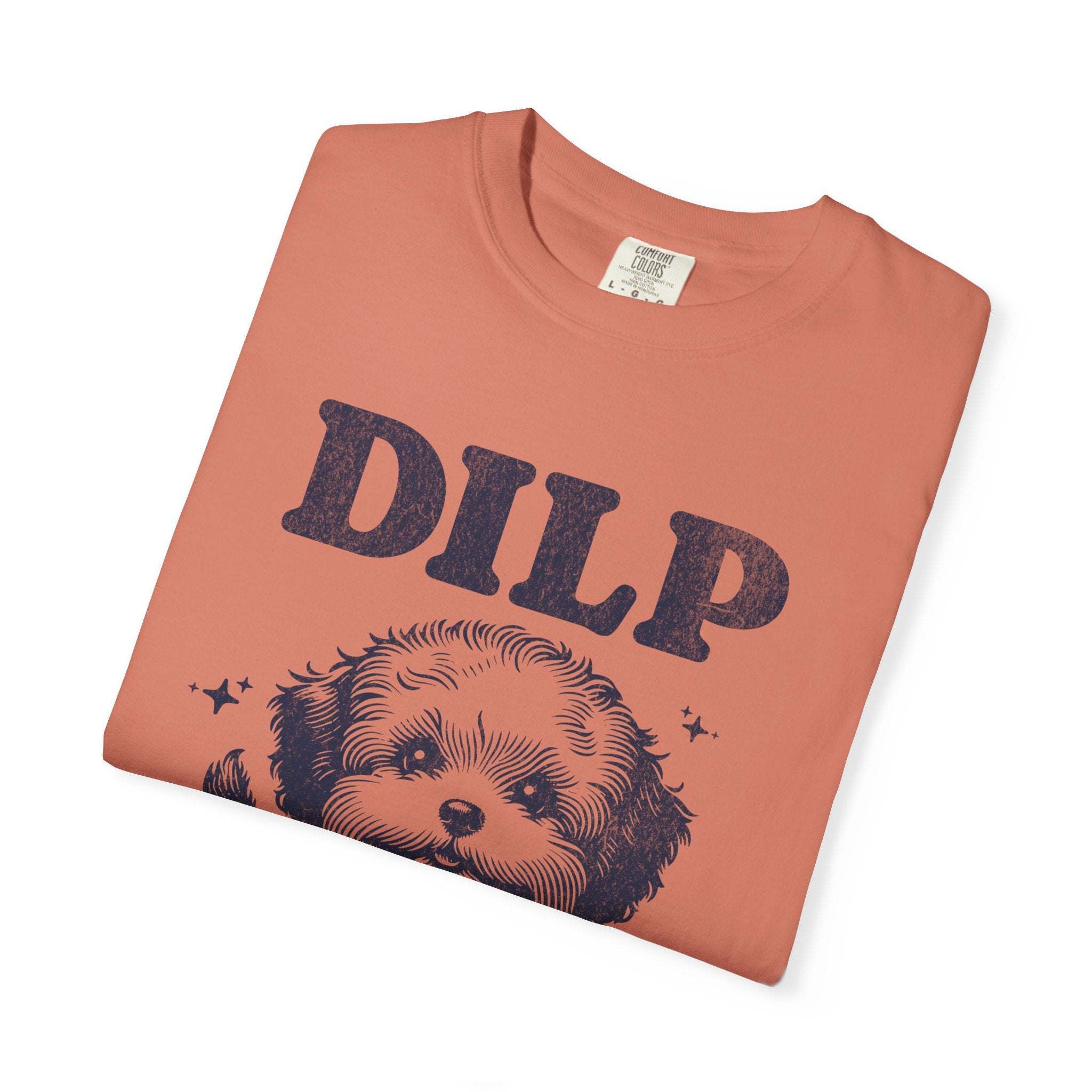 Folded garment-dyed t-shirt with playful dog illustration and DILP text in rust color