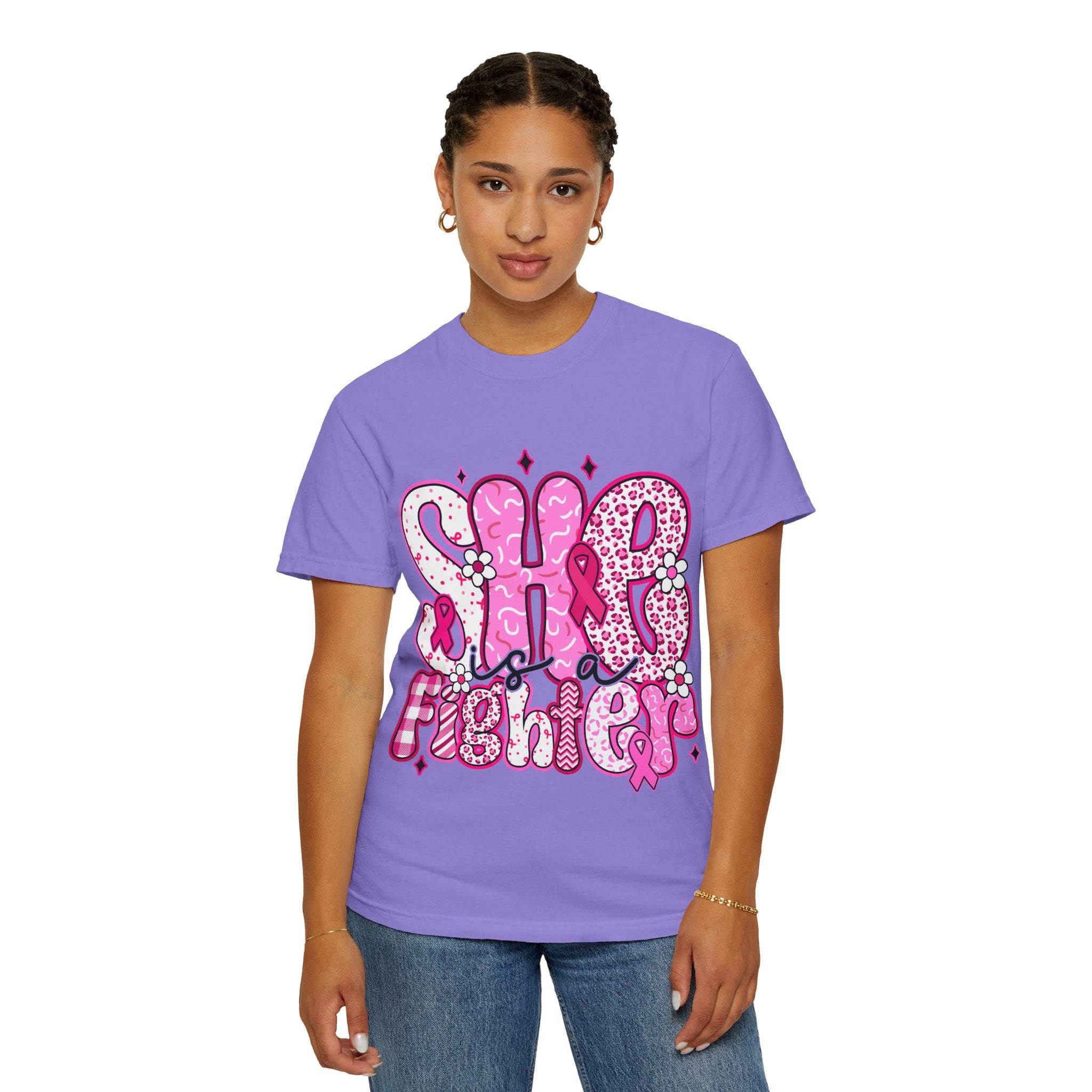 Woman wearing lavender Fighter Breast Cancer T-shirt with graphic text design and pink ribbon symbol