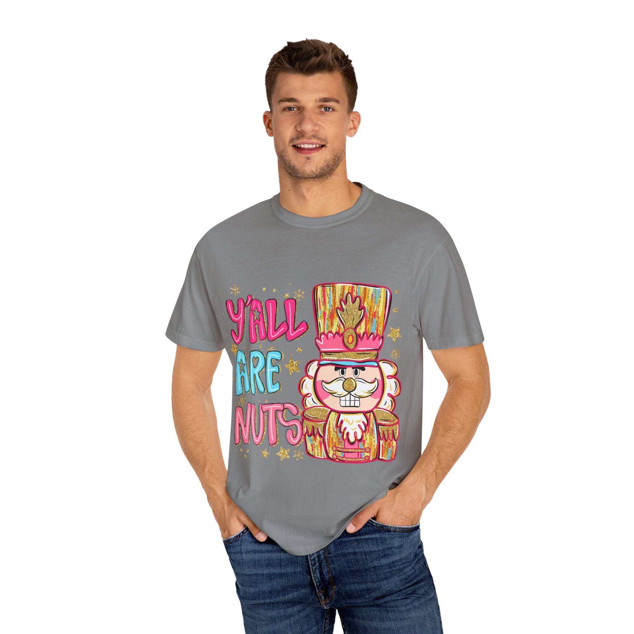 Man wearing a gray Yall Are Nuts Nutcracker T-shirt with colorful festive nutcracker design and text.