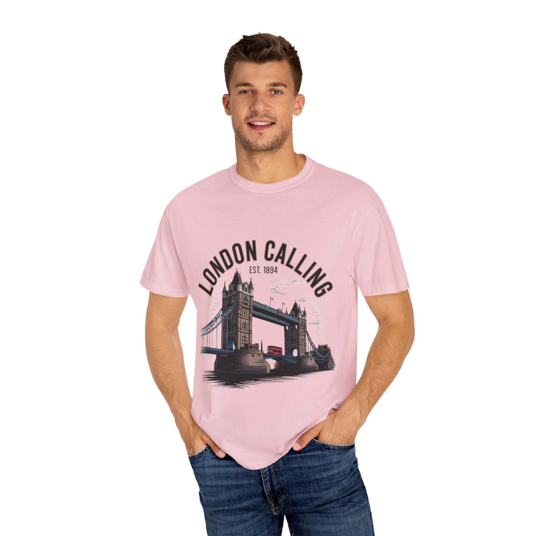Man wearing pink London Calling Travel T-shirt with Tower Bridge graphic, casual unisex cotton tee
