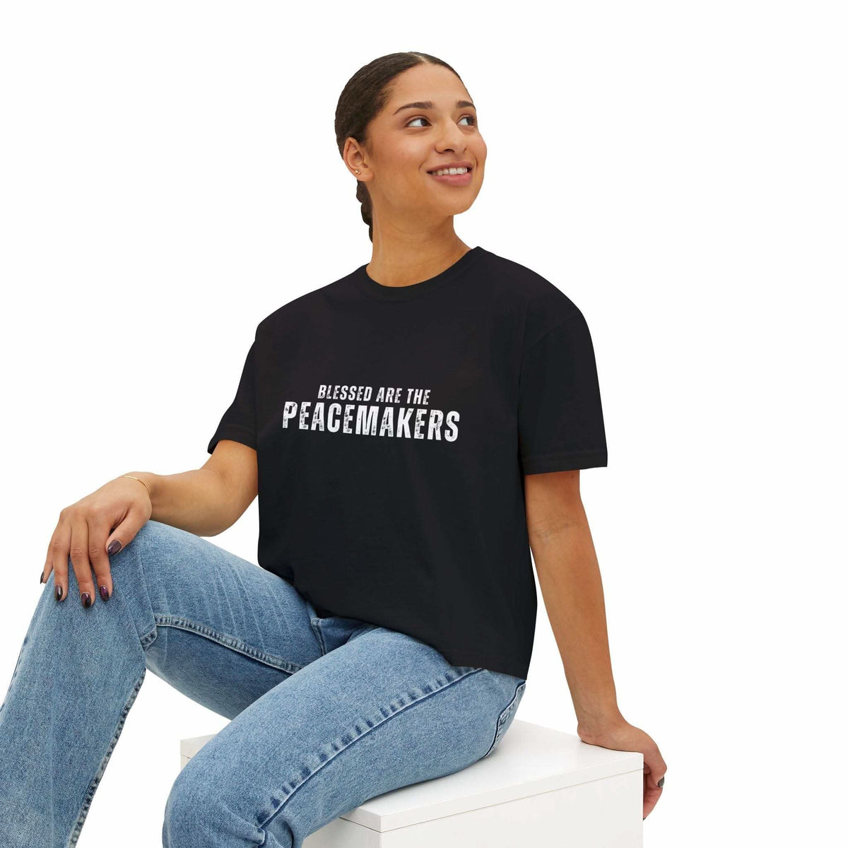 Women's black boxy tee Blessed be the Peacemakers with white text, styled with jeans