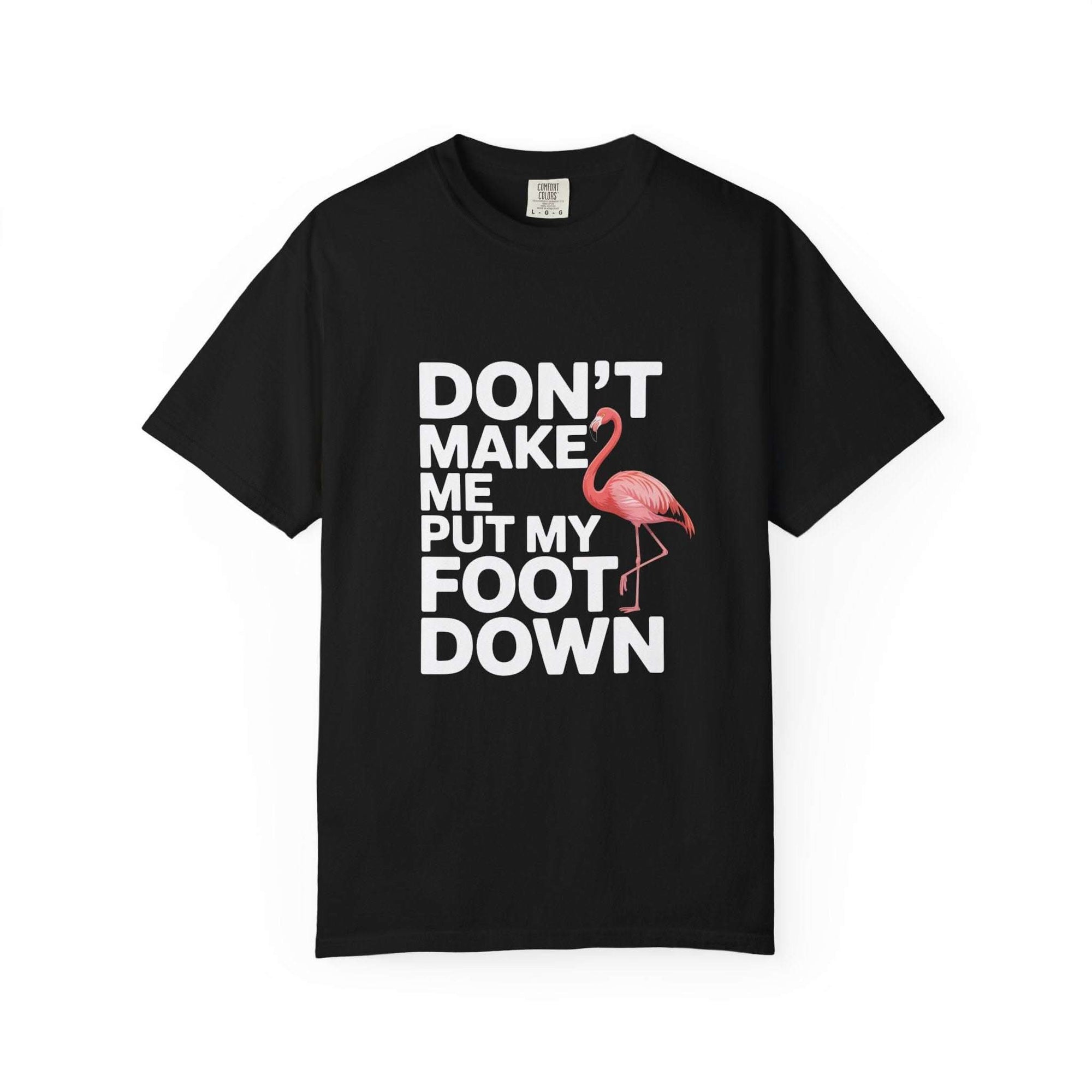 Funny Dont Make Me Put My Foot Down flamingo T-shirt with bold white lettering and pink bird graphic on vintage garment-dyed cotton