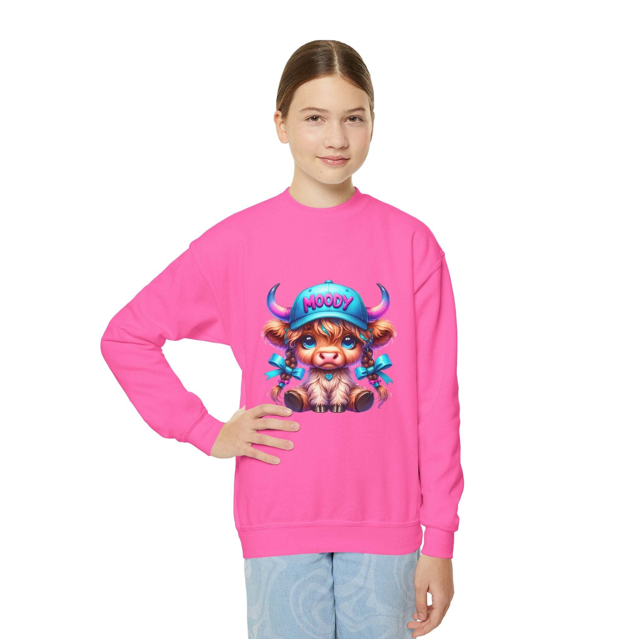Girl wearing bright pink Moody Girl Highland Cow sweatshirt with colorful cartoon cow design on front