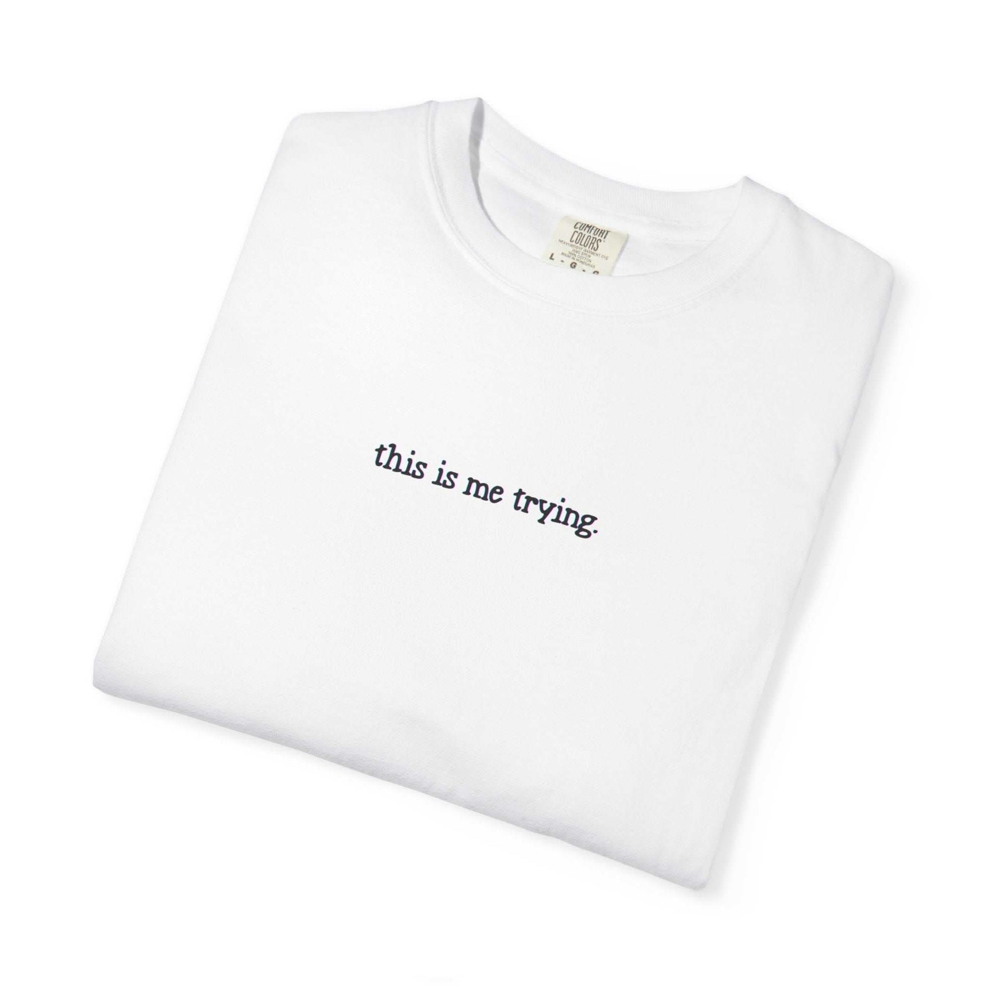 White t-shirt with 'this is me trying' text on a white background