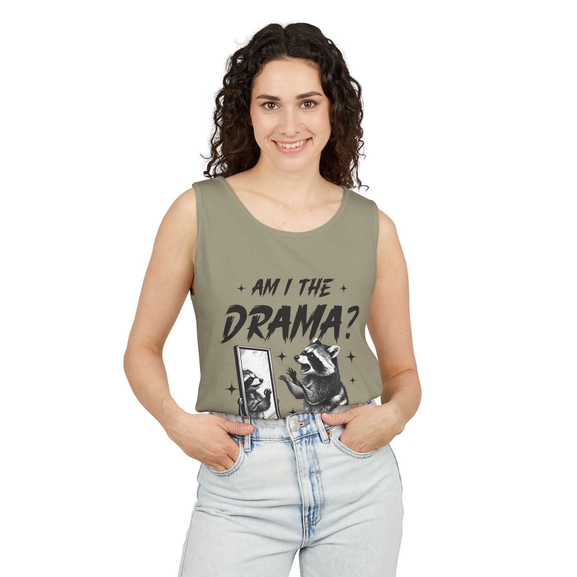 Woman wearing olive green tank top with "Am I The Drama?" text and raccoon graphic, casual summer fashion