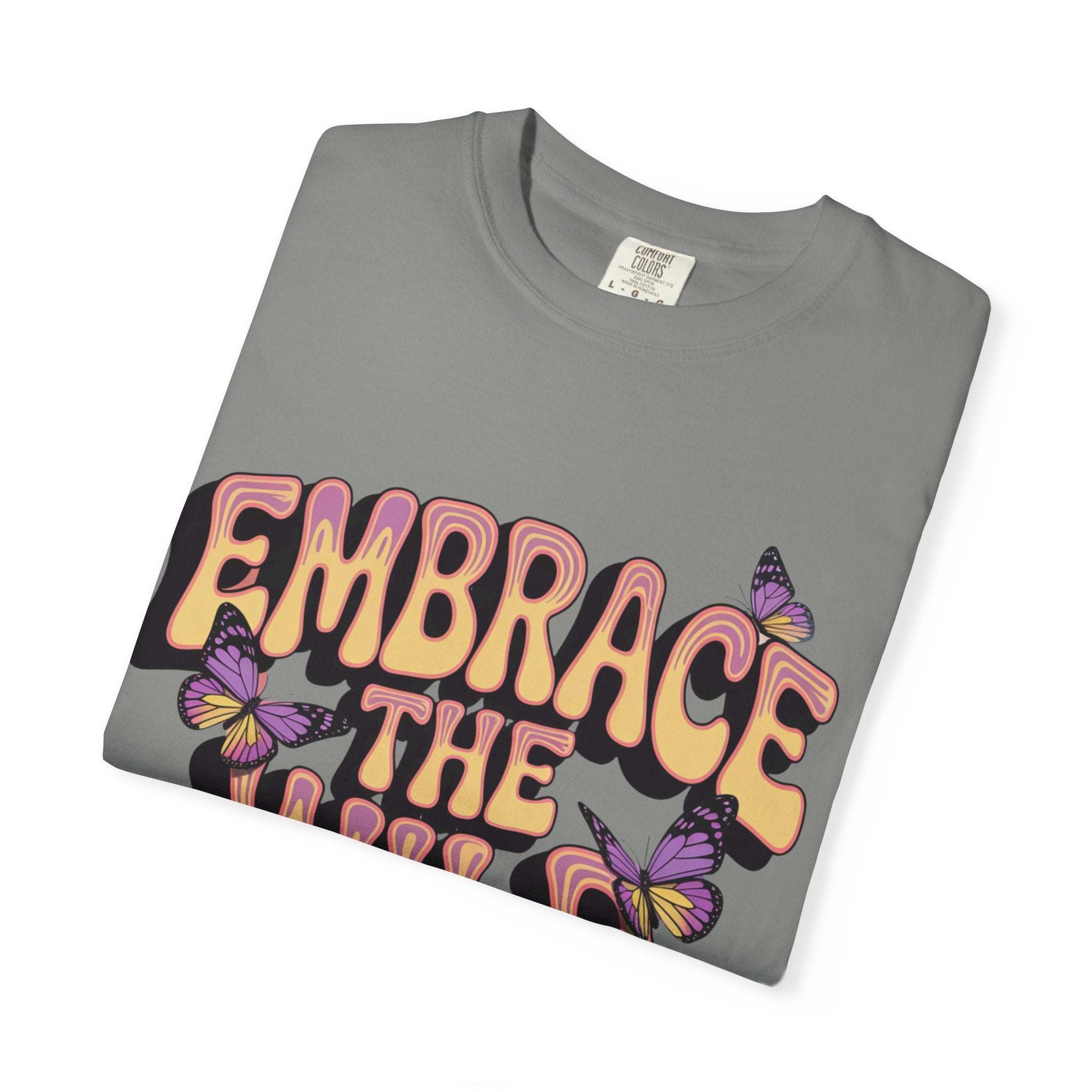 Folded gray garment-dyed T-shirt with "Embrace the Wild Side" text and butterfly print