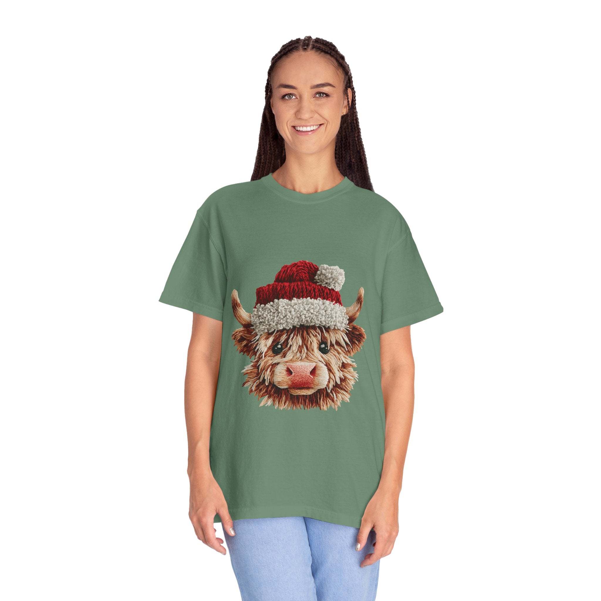 Woman wearing green t-shirt with faux crochet yarn Highland cow Santa print design