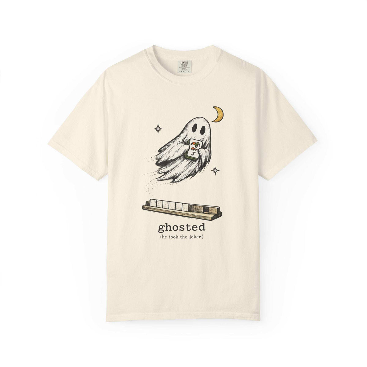 Flat lay of an ivory mahjong T-shirt with a ghost holding a joker tile above a tile rack and “ghosted (he took the joker)” lettering.