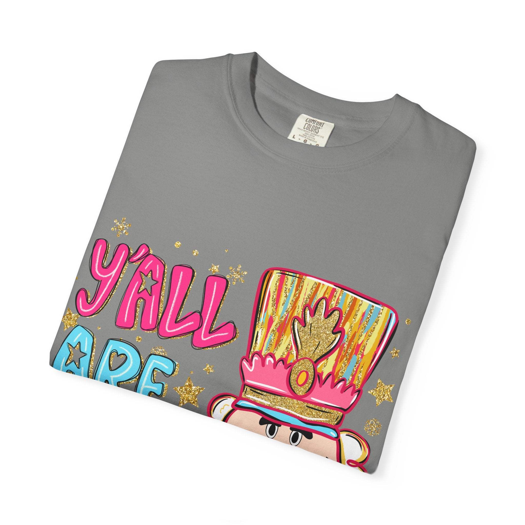 Folded gray T-shirt with colorful Yall Are Nuts Nutcracker graphic design and festive text