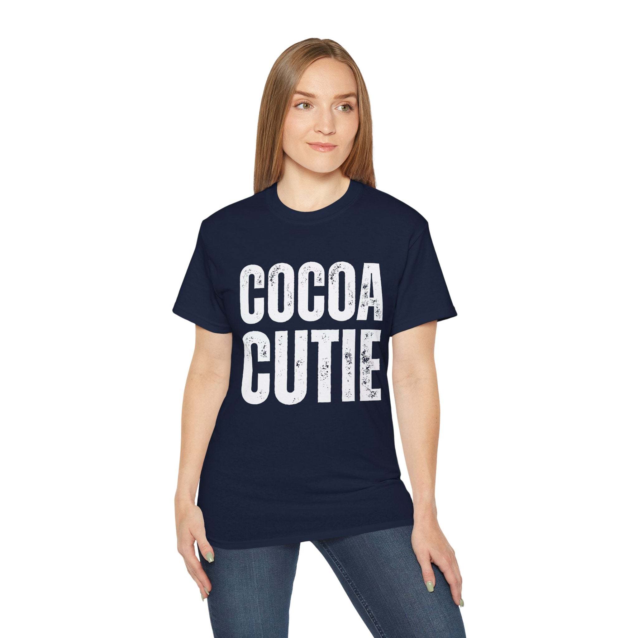 Woman wearing navy distressed Cocoa Cutie Tee with bold white text on front