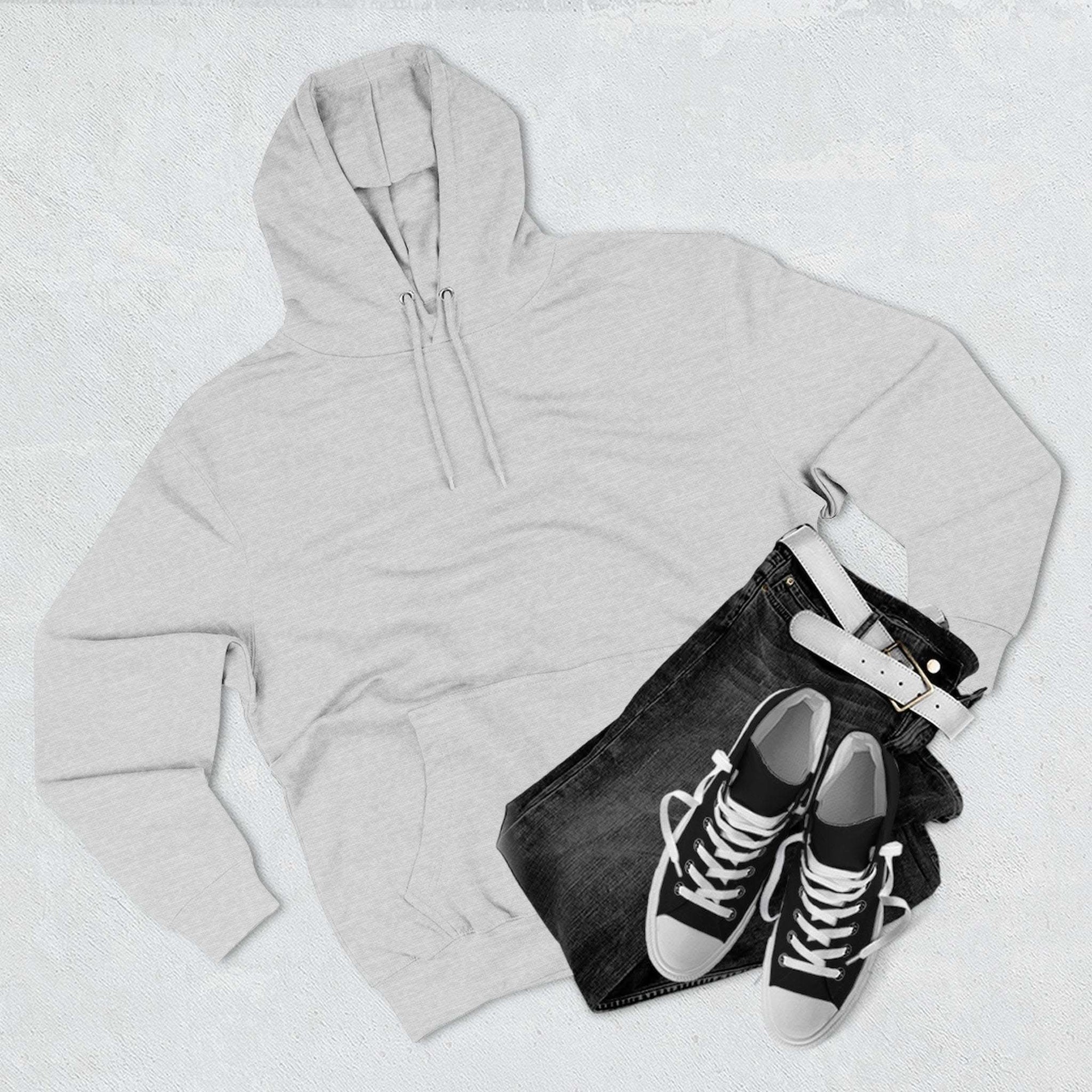 Light grey fleece hoodie with kangaroo pocket, paired with black jeans and black sneakers with white laces.