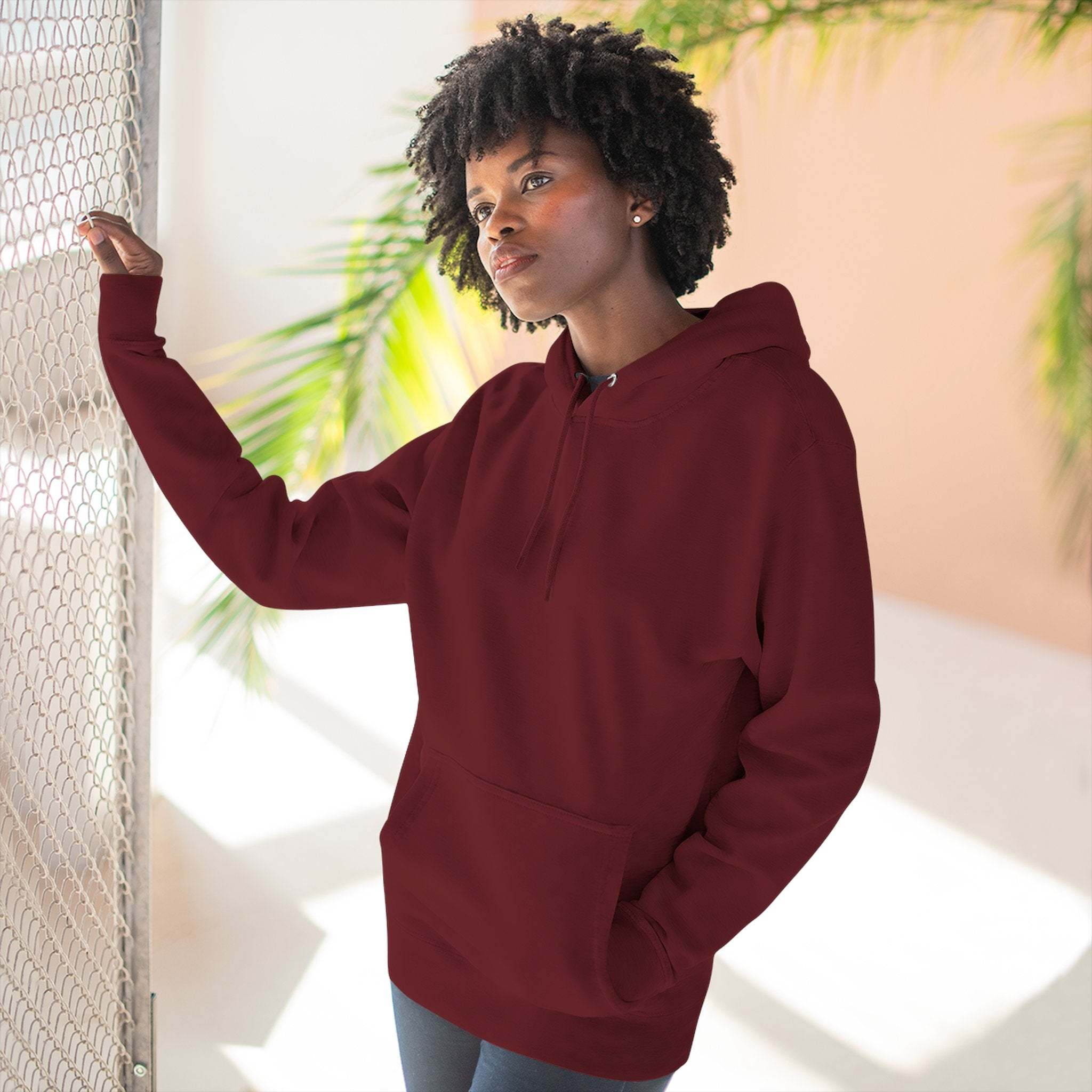 Woman wearing cozy maroon fleece hoodie with kangaroo pocket and adjustable hood indoors