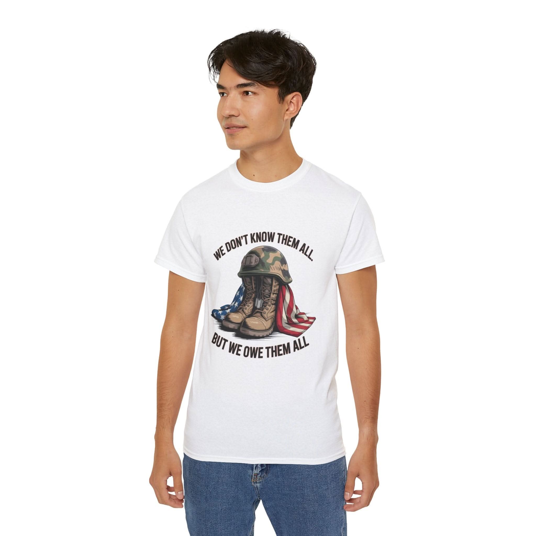 Unisex white T-shirt with military boots, helmet, and American flag graphic and "We Don't Know Them All But We Owe Them All" text