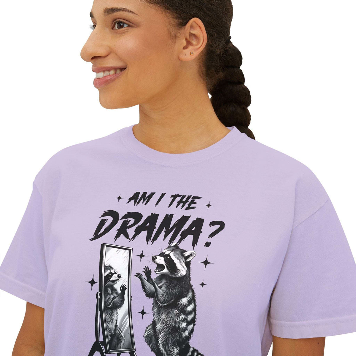 Woman wearing lavender boxy tee with "Am I The Drama?" text and raccoon graphic