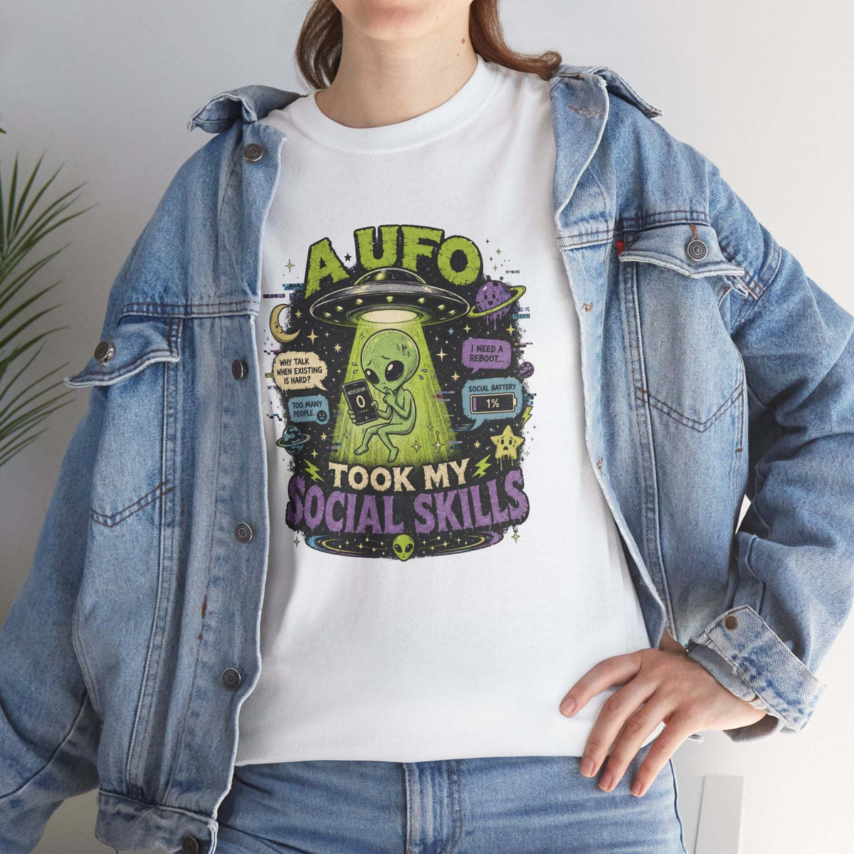 White t-shirt with neon green and purple alien graphic and text "Alien Abduction Took My Social Skills" in playful space design