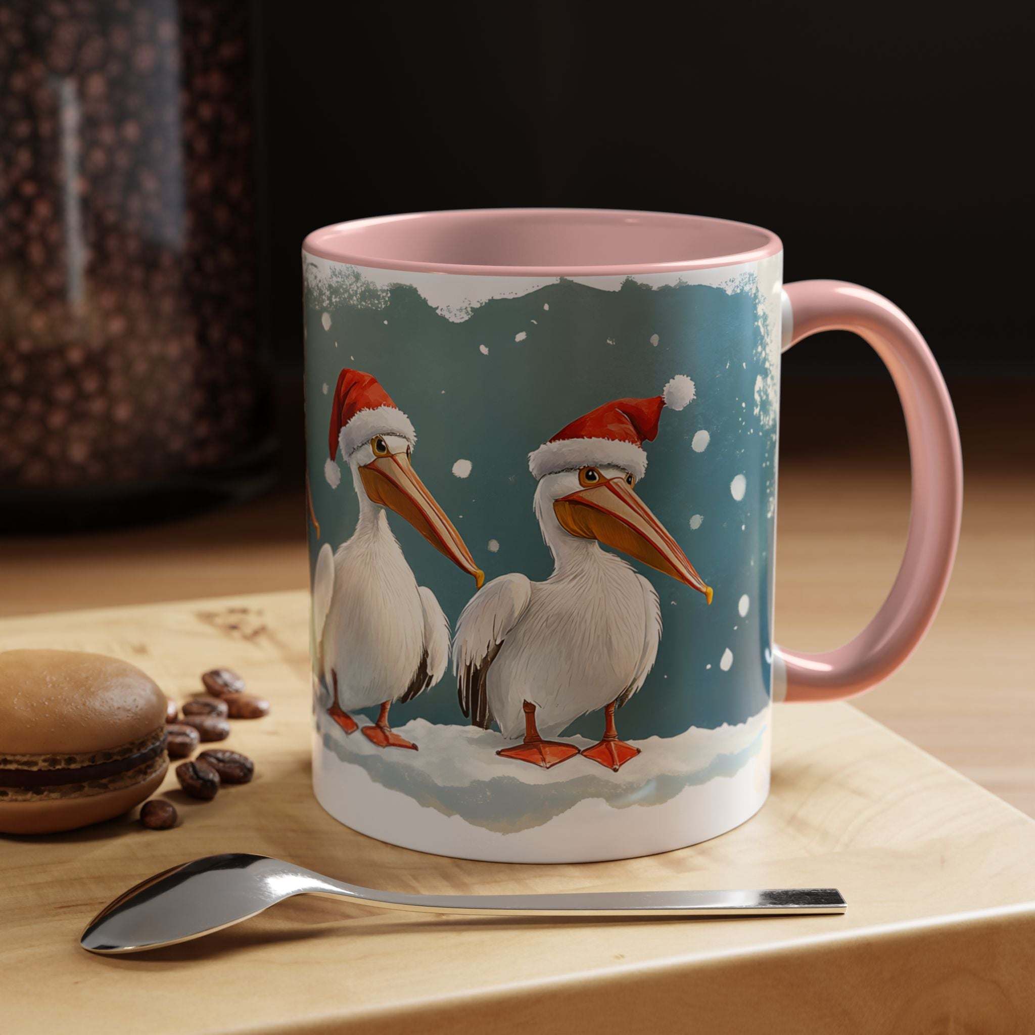 Mug with Christmas-themed design of pelicans wearing Santa hats on a table with coffee beans and a spoon.