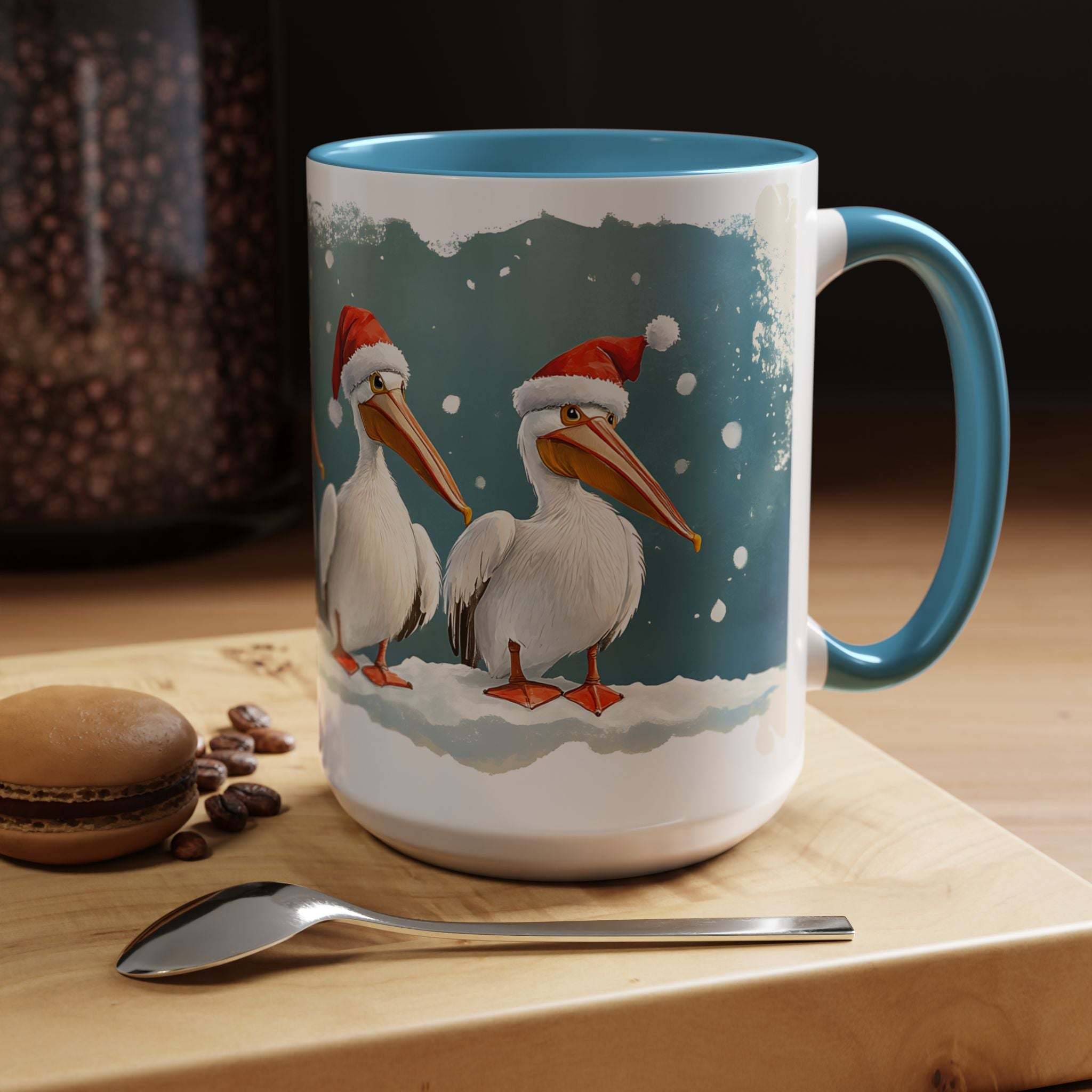 Mug with Christmas-themed design of pelicans wearing Santa hats on a wooden surface with coffee beans and a spoon.