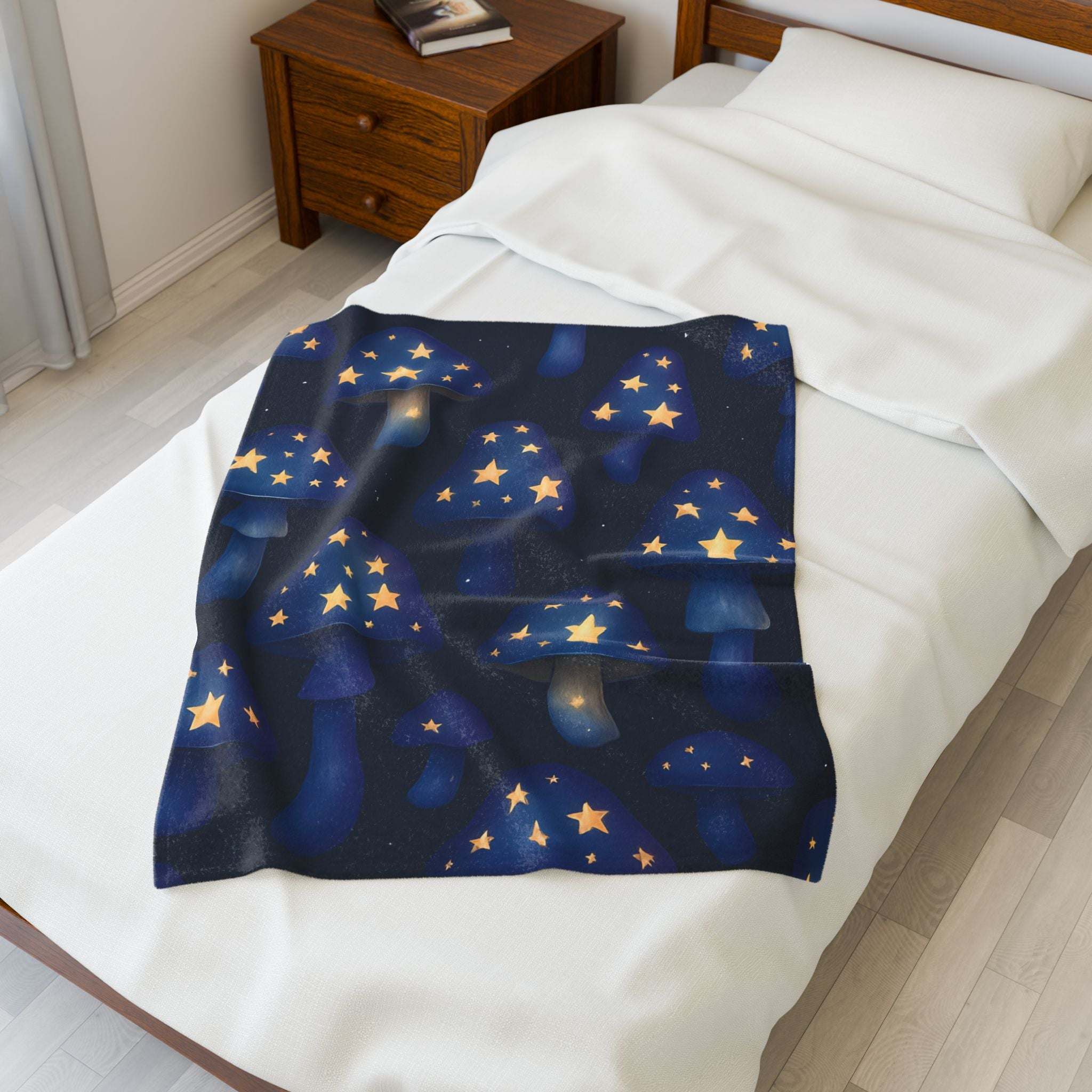 Velveteen plush blanket with whimsical glowing mushrooms and stars on bed
