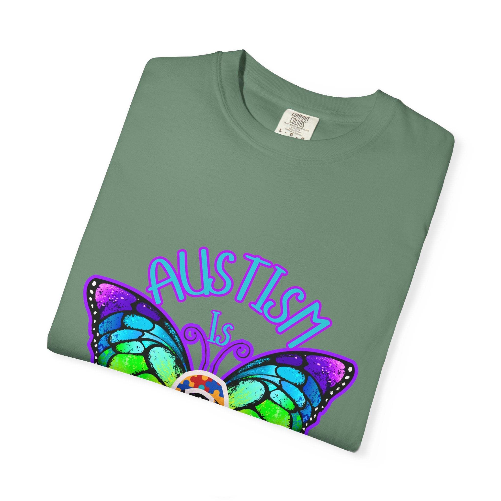 Autism is Beautiful T-shirt with colorful butterfly design promoting autism awareness and acceptance on soft green fabric