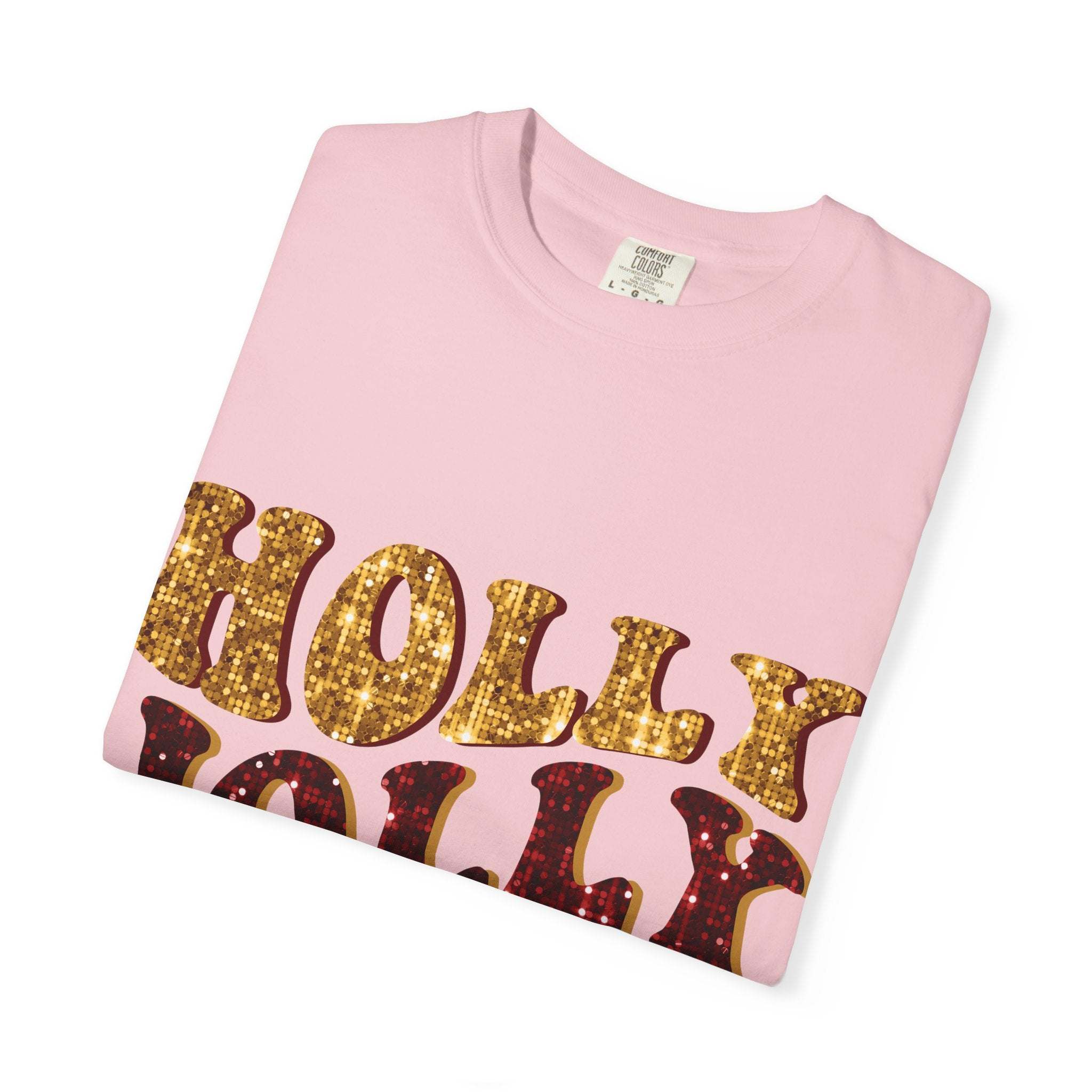 pink Faux Glitter Holly Jolly Mama t-shirt with gold and red glitter text folded on white background