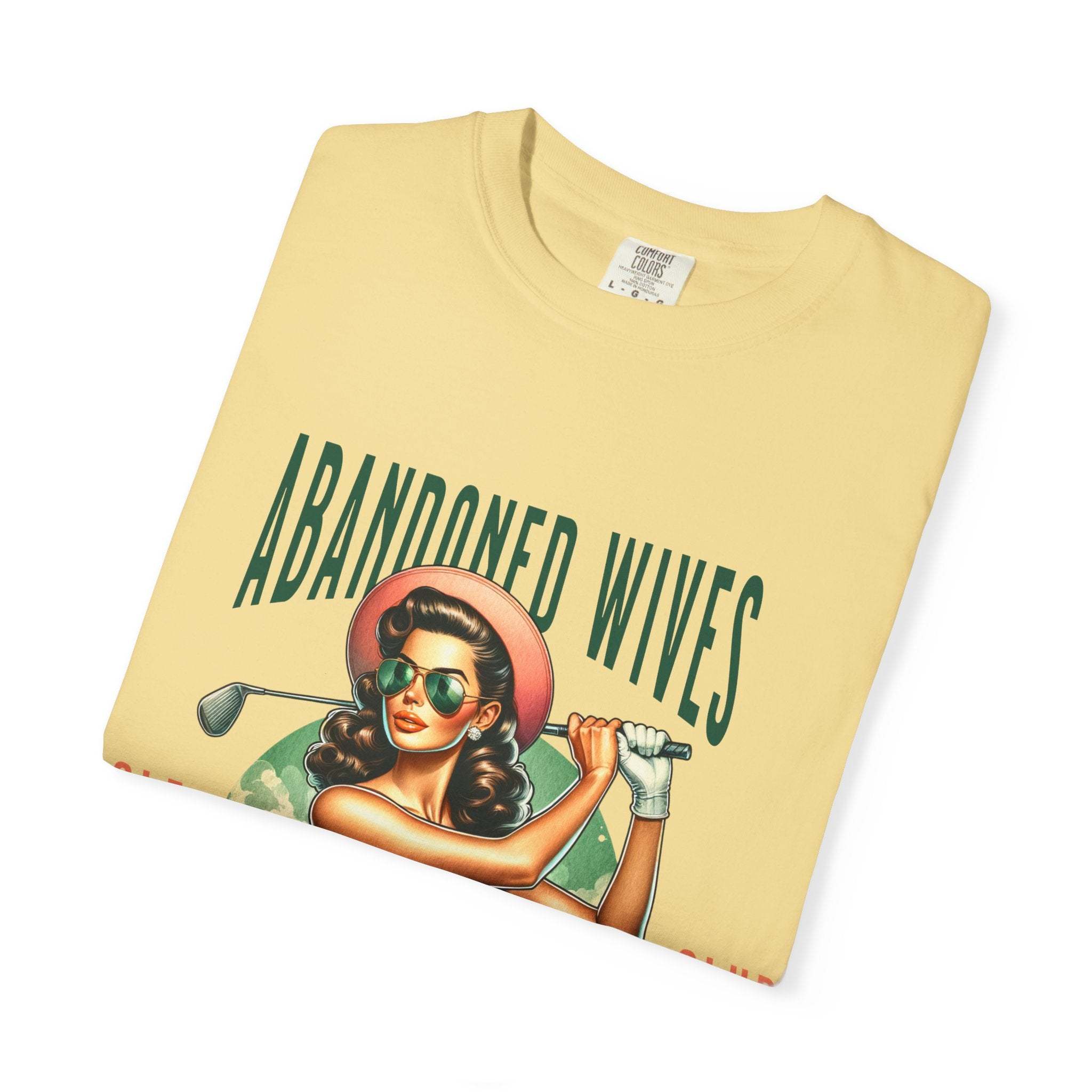 Vintage unisex t-shirt with humorous Abandoned Wives Golf Club design featuring a retro woman golfer illustration on soft garment-dyed cotton
