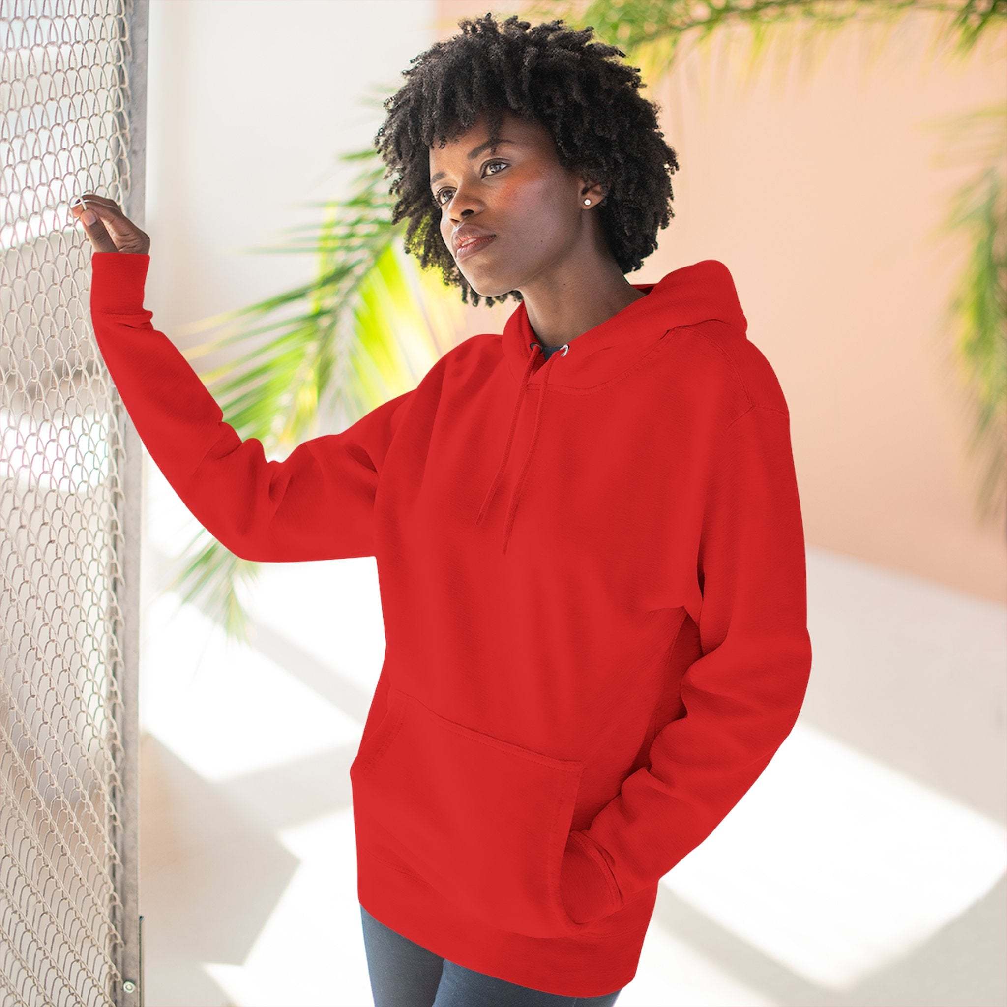 Woman wearing red cozy fleece hoodie with kangaroo pocket and adjustable hood in bright room