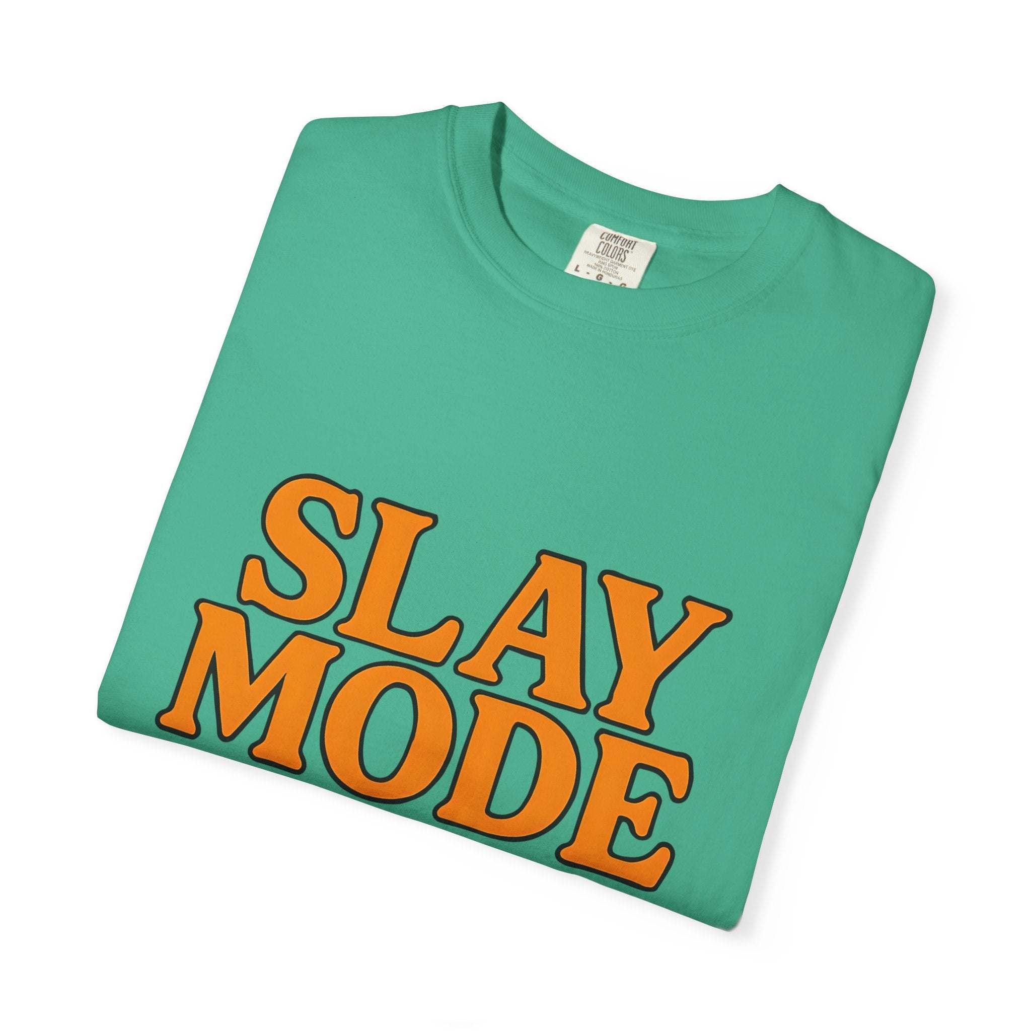 Folded garment-dyed tee in teal with bold orange "Slay Mode" text, 100% cotton casual shirt for empowerment and comfort