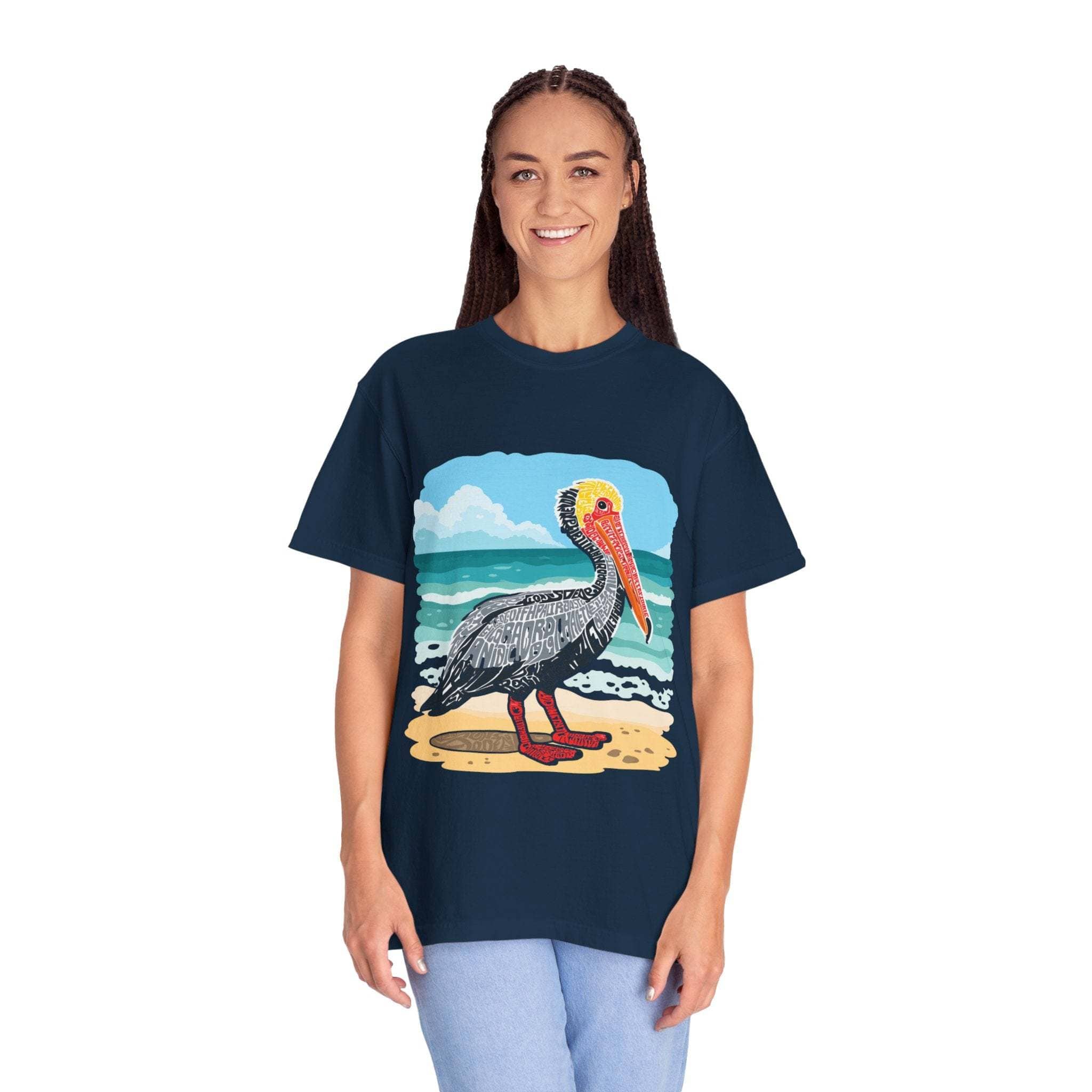 Woman wearing navy Pelican Letter Poster graphic tee with vintage coastal pelican design on beach background