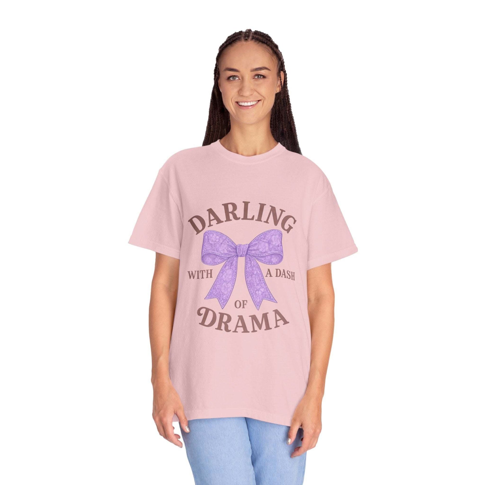 Person wearing a pink t-shirt with a purple bow and text on a white background
