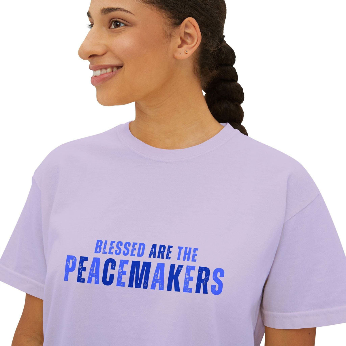 Woman wearing lavender Tee Blessed be the Peacemakers boxy shirt with blue text print