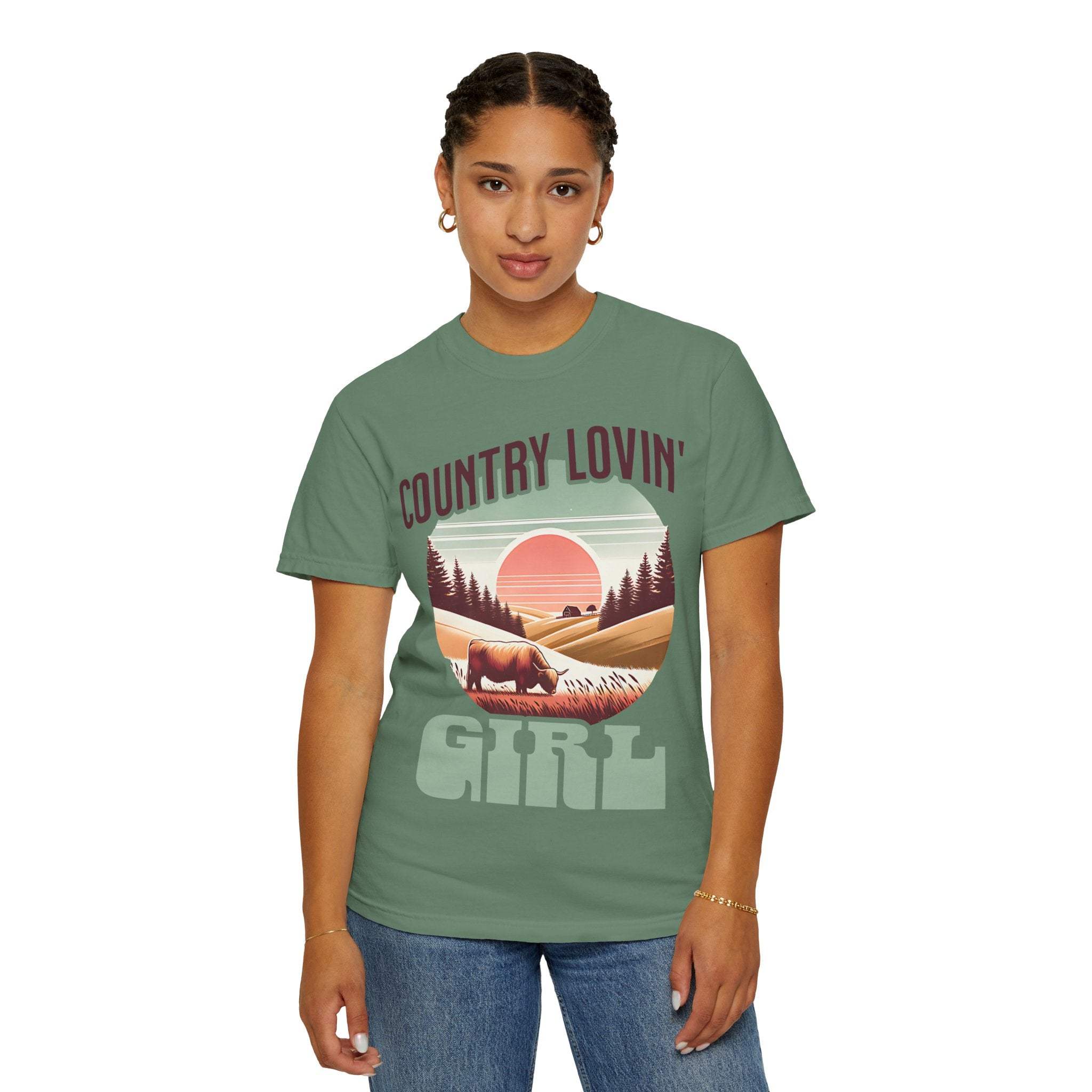 Woman wearing a green Country Lovin Girl T-shirt with vintage countryside graphic and relaxed fit