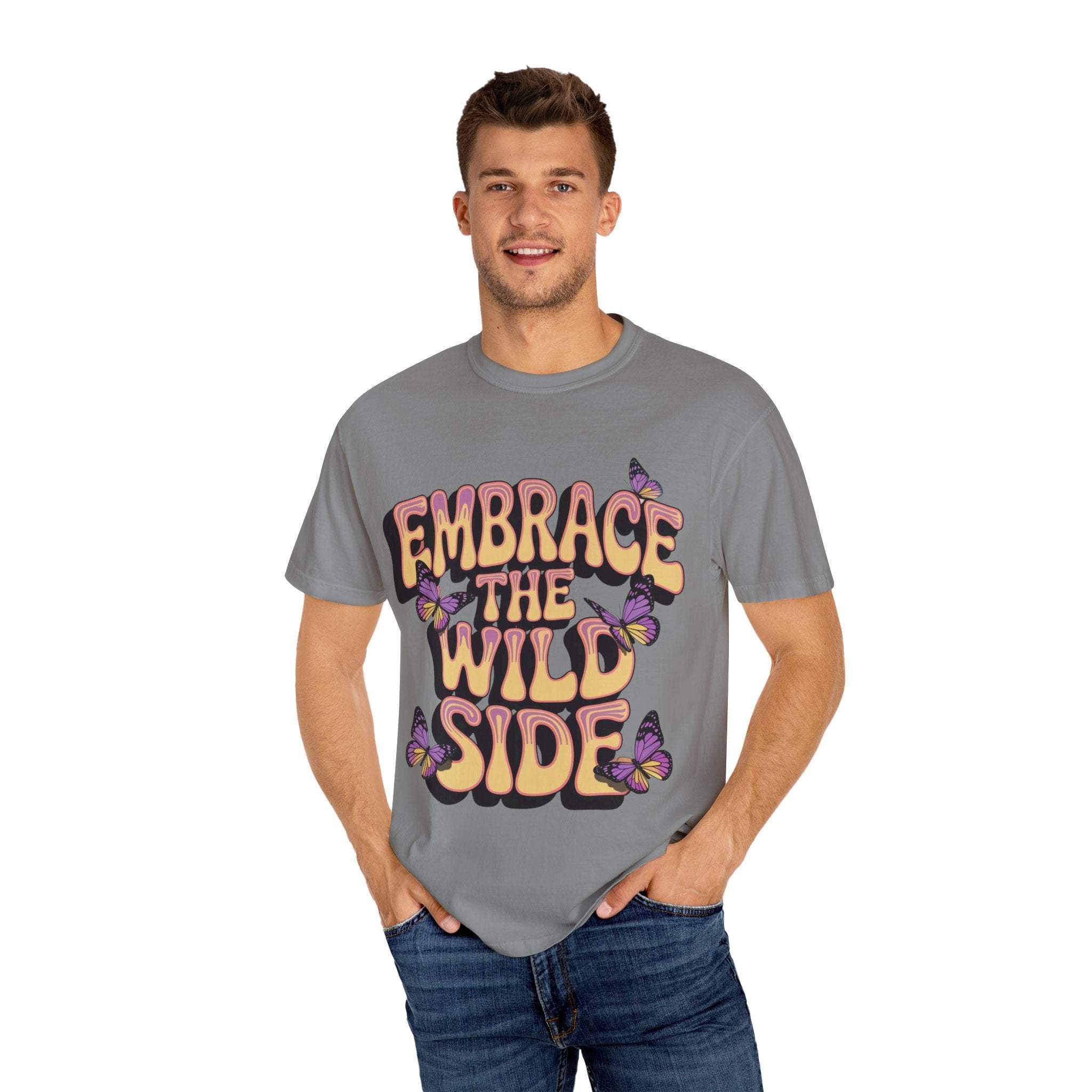 Unisex grey garment-dyed T-shirt with "Embrace the Wild Side" print and butterfly design worn by smiling male model