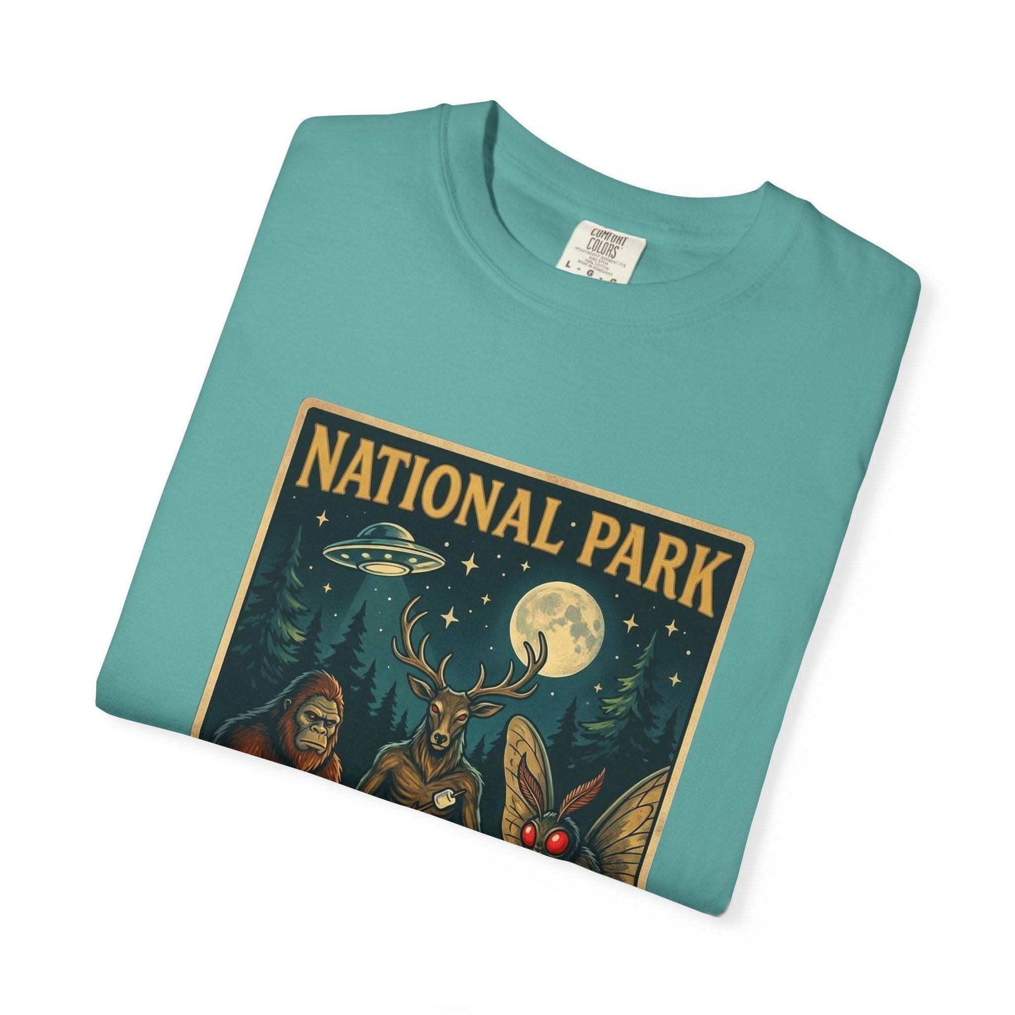 National Park After Dark T-shirt with campfire, Sasquatch, Mothman, and night creatures design on vintage-style garment-dyed fabric