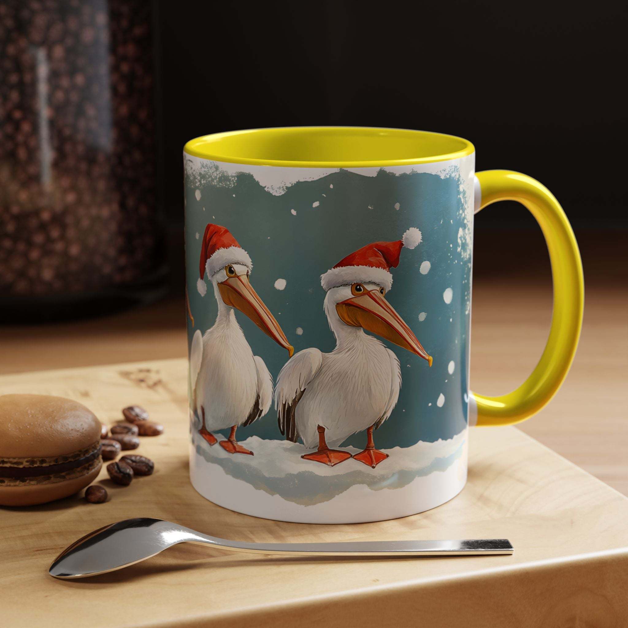 Mug with Christmas design of pelicans wearing Santa hats on a table with coffee beans and a spoon.
