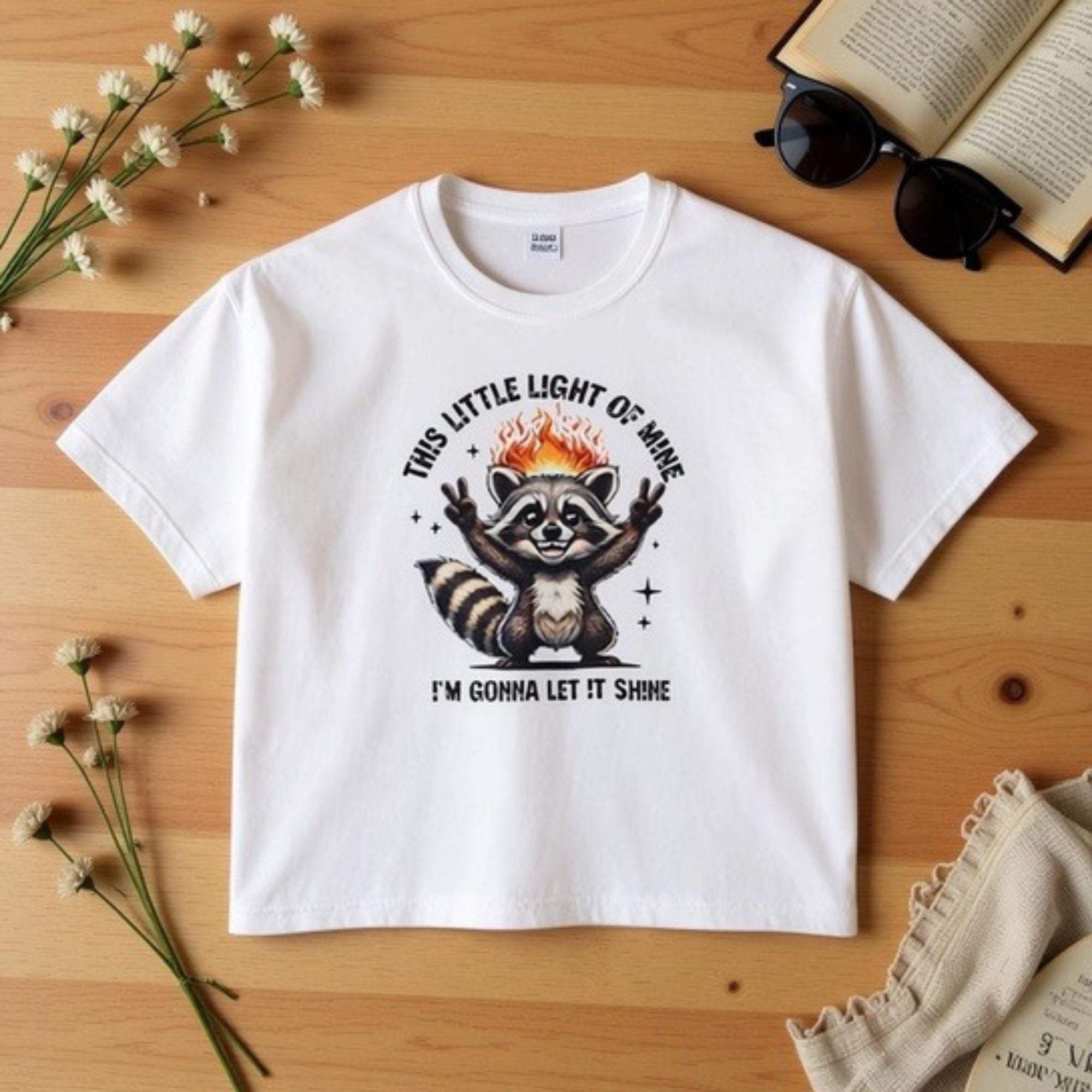 White women's boxy tee with sarcastic raccoon and "This Little Light of Mine" graphic