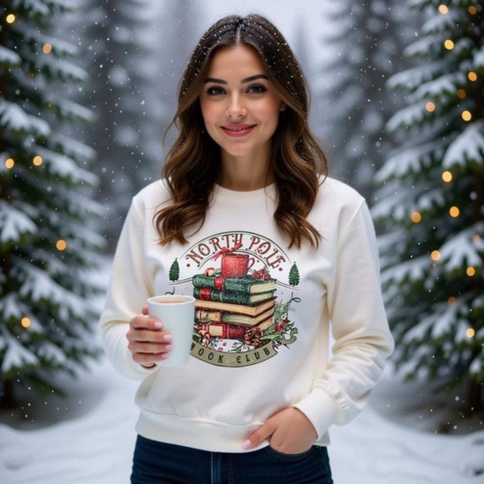 woman wearing Vintage North Pole Book Club sweatshirt holding white mug in snowy forest