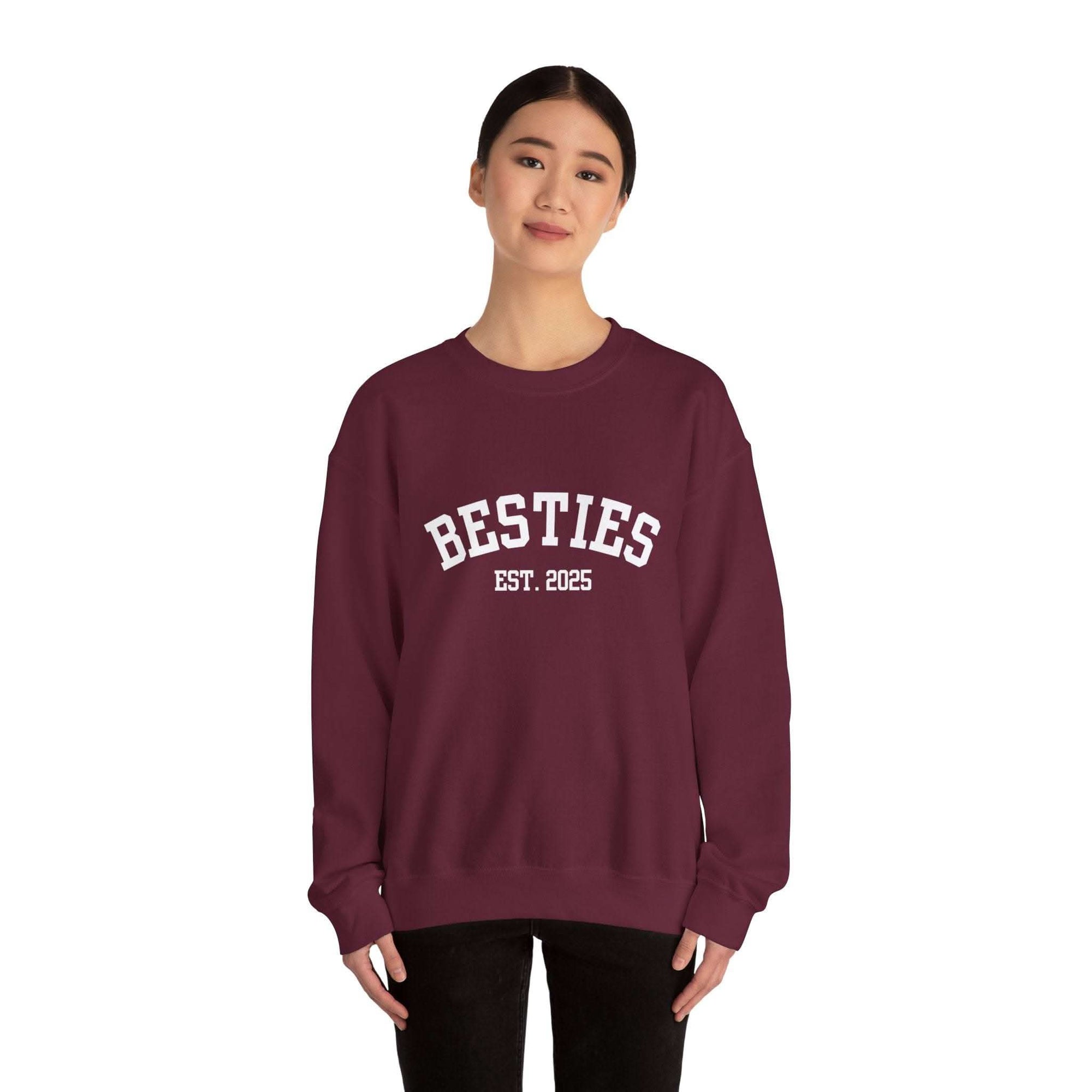 woman wearing maroon Varsity Besties Crewneck Sweatshirt with white "BESTIES EST. 2025" varsity-style lettering