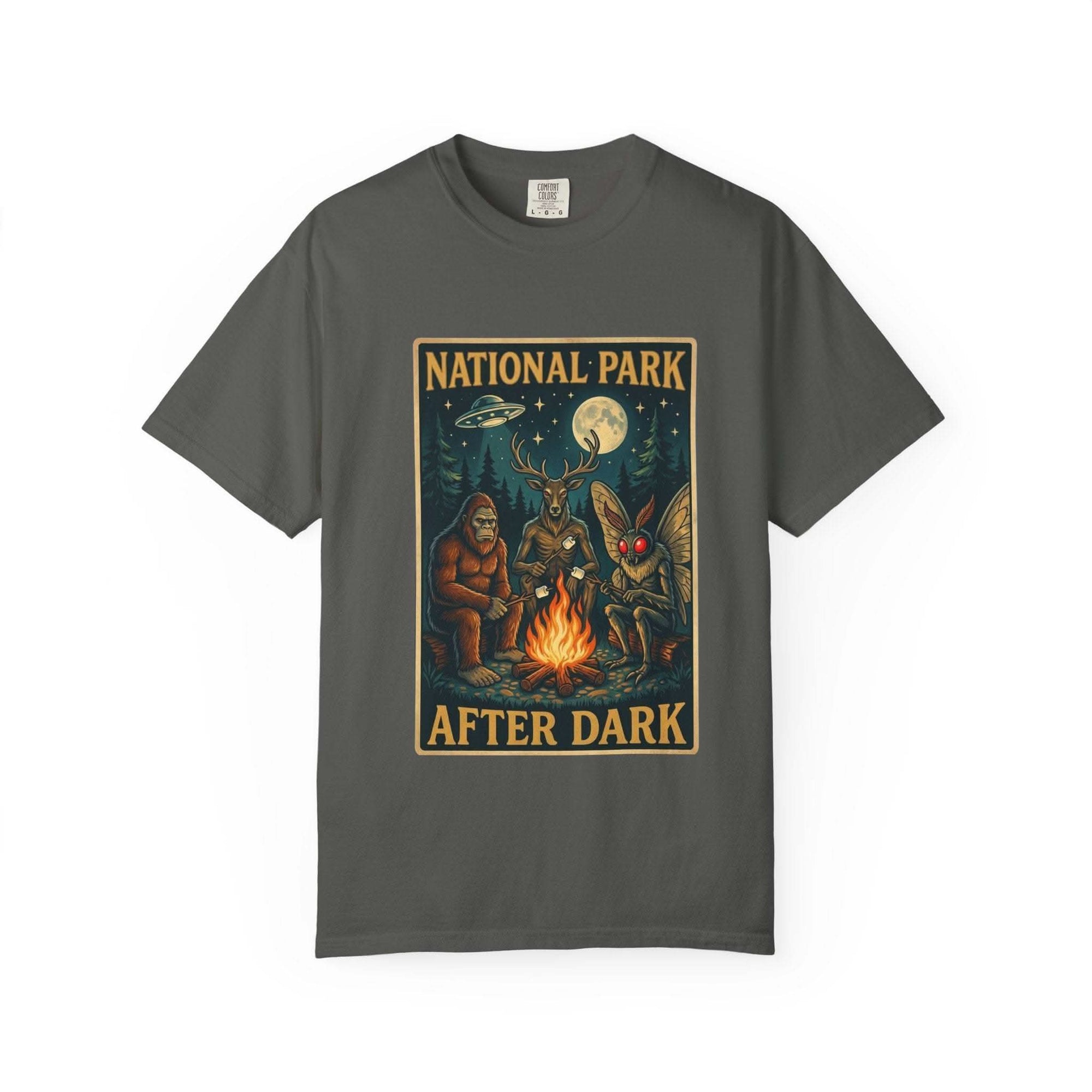 National Park After Dark t-shirt featuring campfire, Sasquatch, Mothman, and nocturnal creatures in a vintage woodland night scene