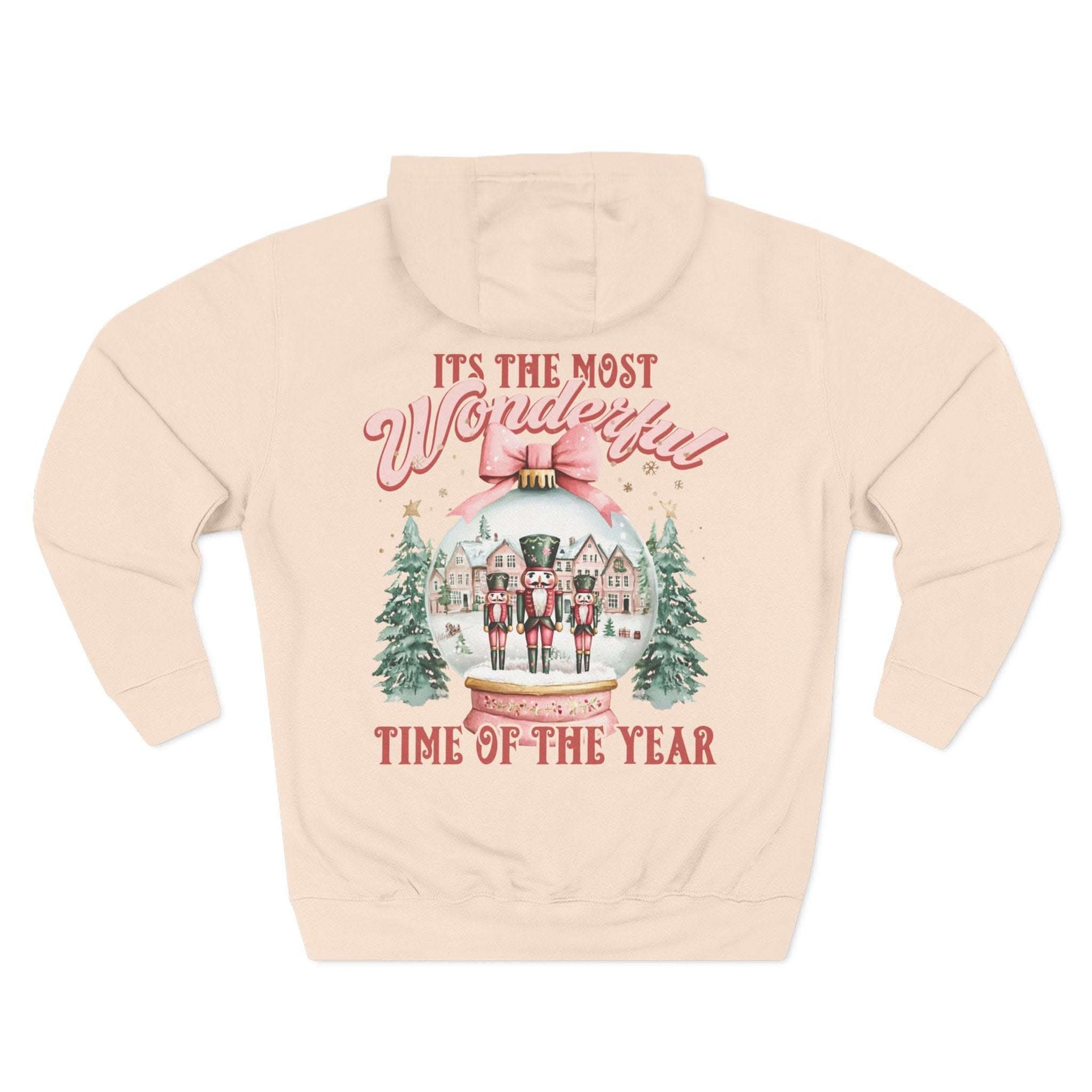 Preppy pink fleece hoodie with vintage snow globe and nutcracker design for cozy winter comfort
