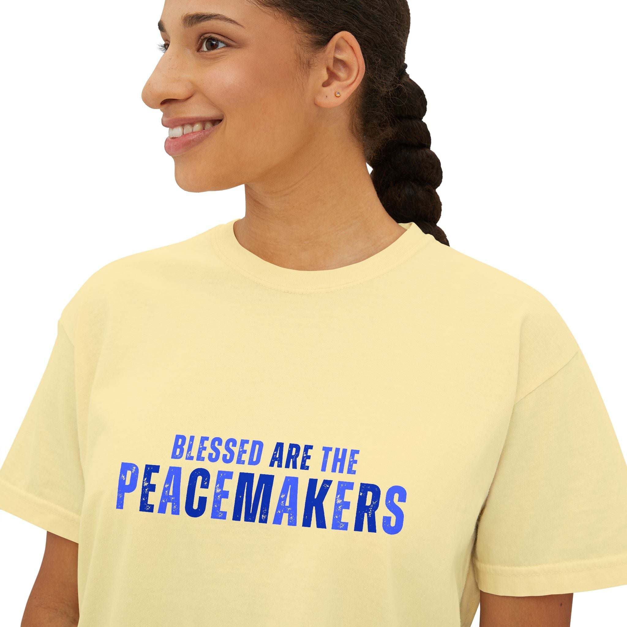 Woman wearing yellow Tee Blessed be the Peacemakers with blue text, boxy fit, casual style