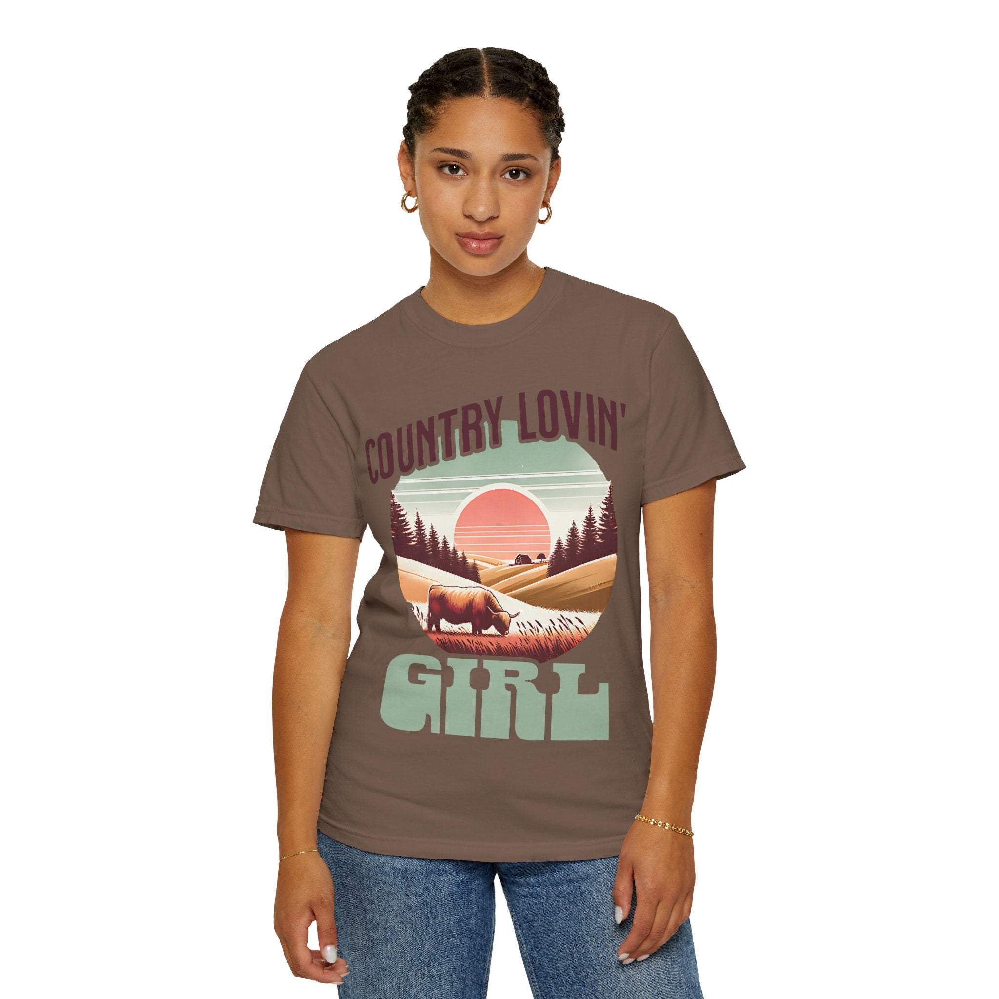 Woman wearing brown Country Lovin Girl T-shirt with vintage sunset and cow design
