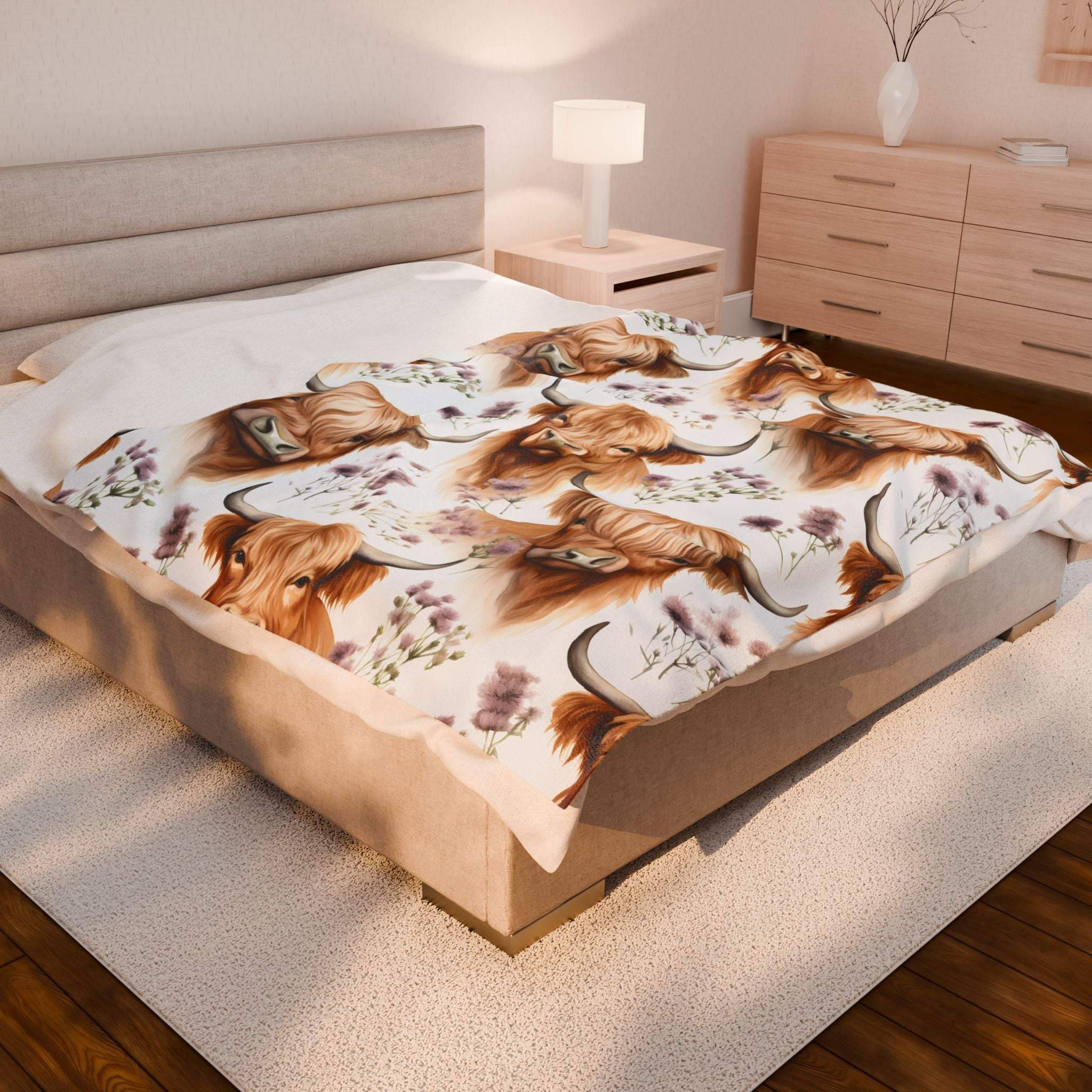 Plush blanket with floral Highland cow design on bed in cozy bedroom setting