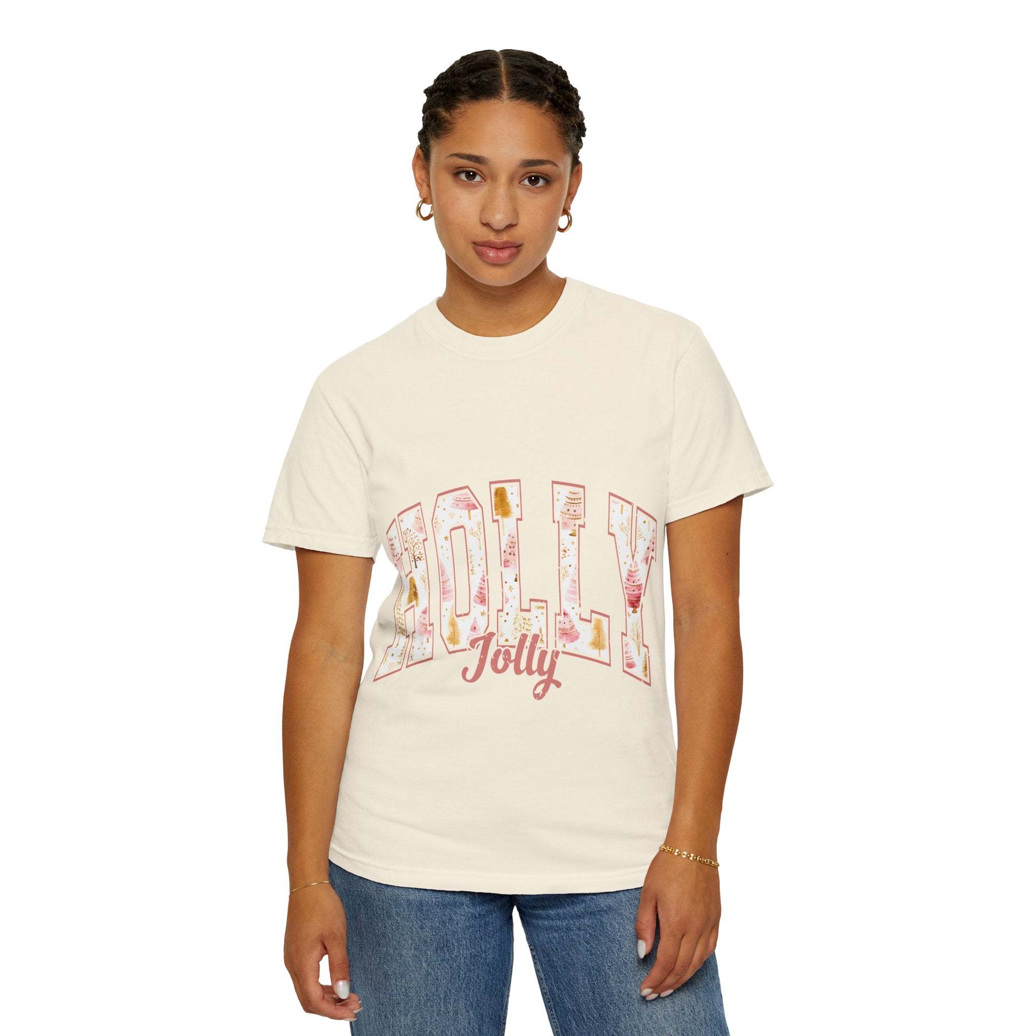 Woman wearing varsity holly jolly t-shirt in cream color with festive lettering, casual relaxed fit, and denim jeans.