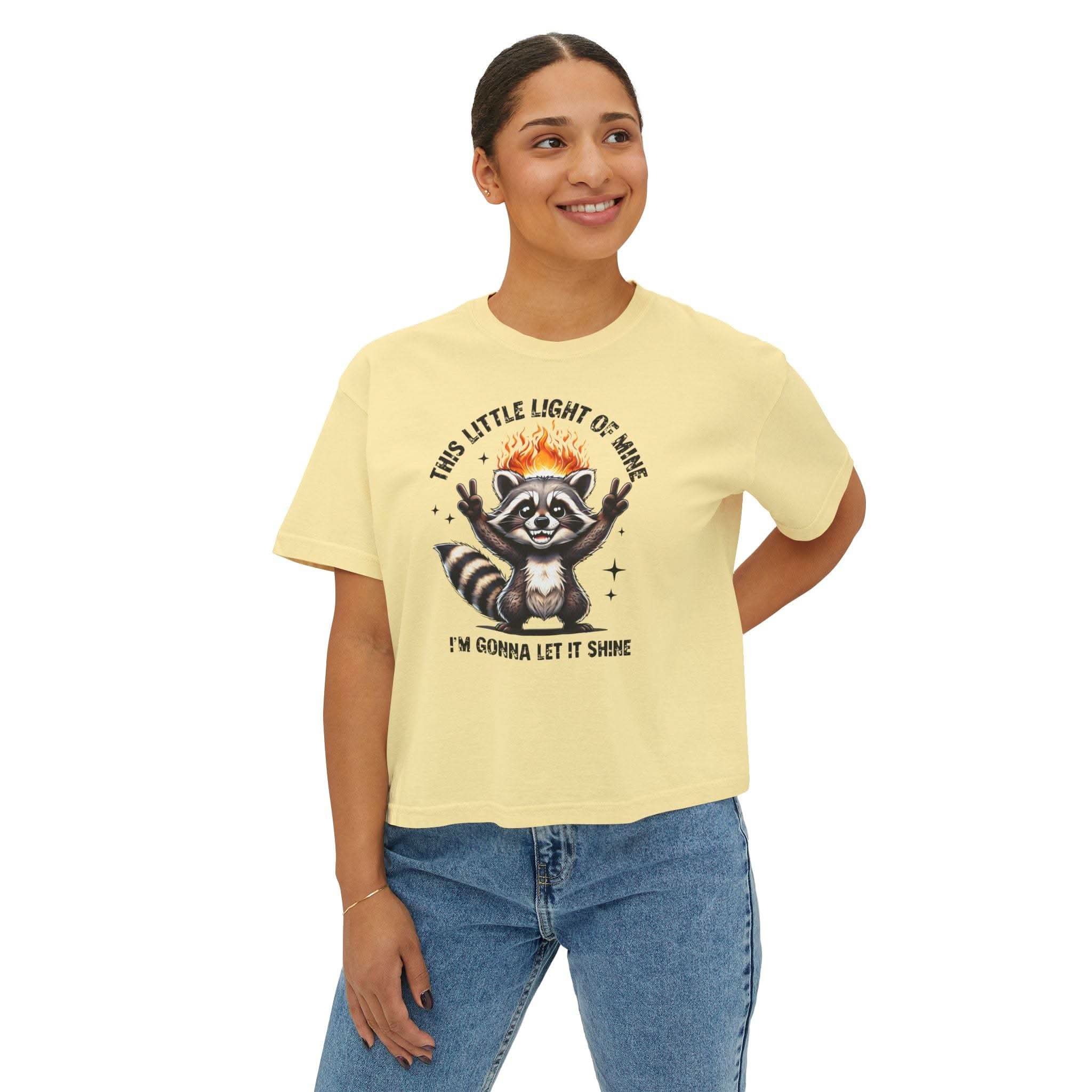 Woman wearing a yellow t-shirt with a raccoon graphic and text on a white background