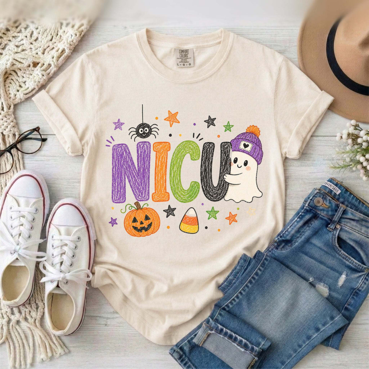 Ivory NICU nurse Halloween T-shirt with colorful crayon-style lettering, a smiling ghost in a purple beanie, pumpkin, and candy corn.