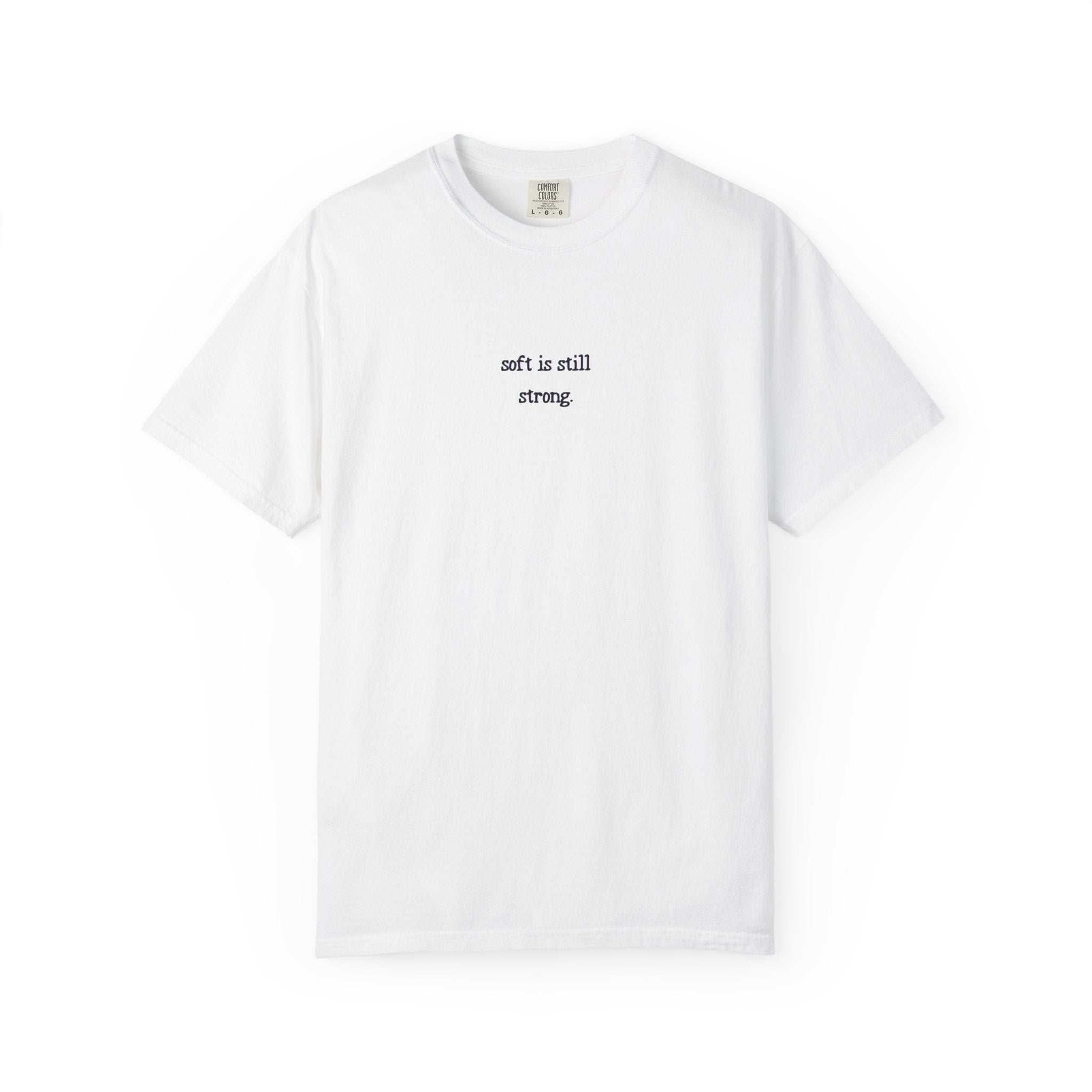 White t-shirt with text 'soft is still strong' on a white background