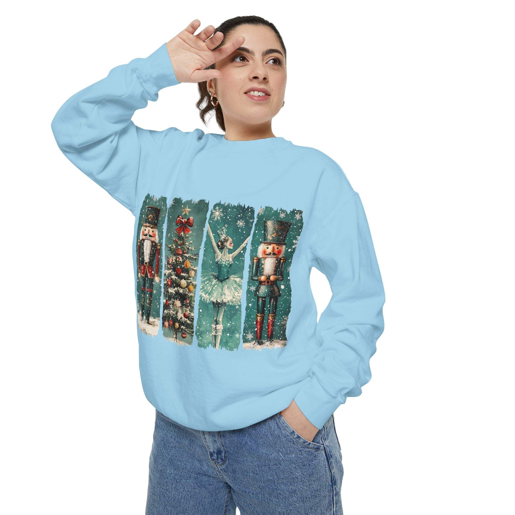 Woman wearing light blue vintage Christmas nutcracker sweatshirt with holiday-themed watercolor nutcracker and ballerina design