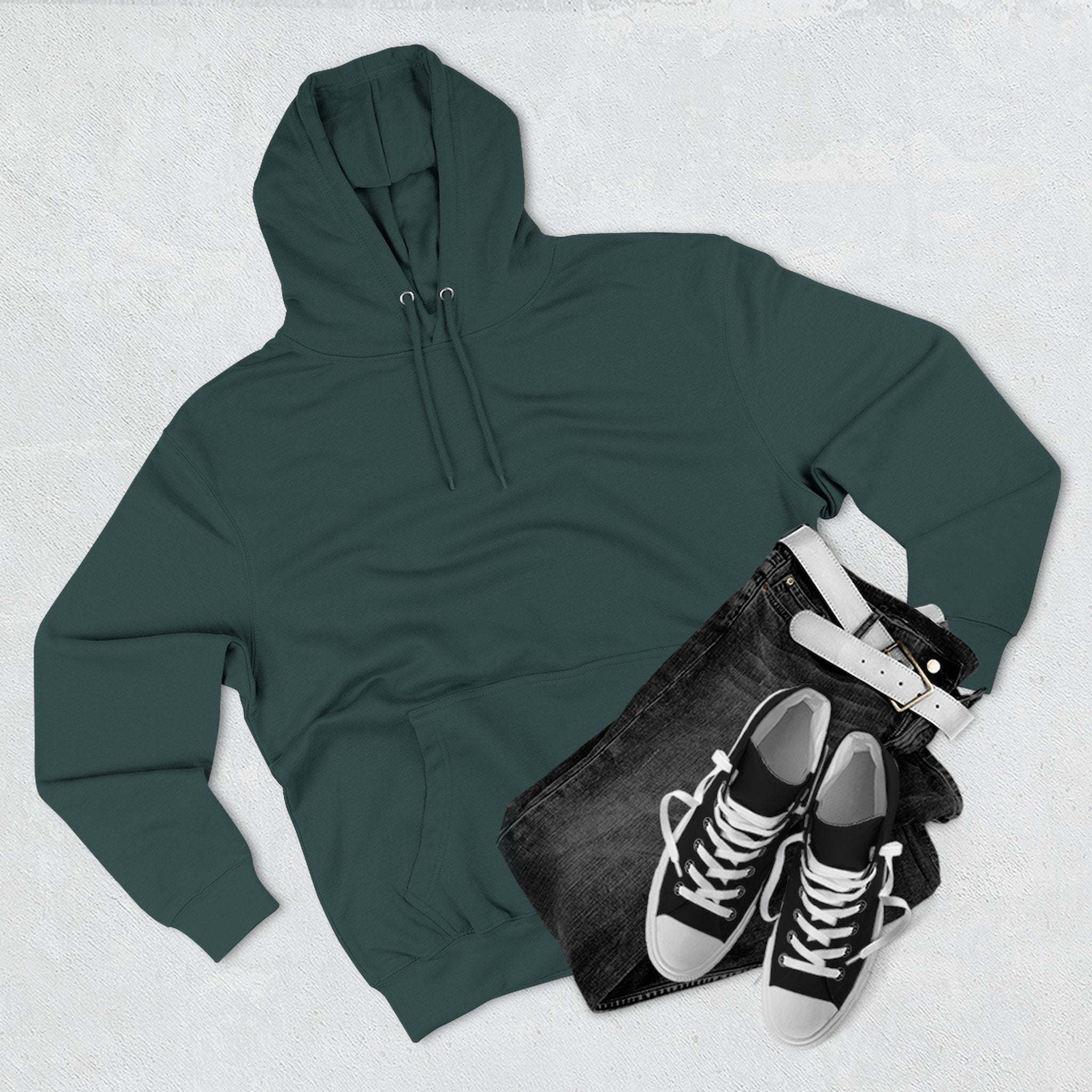 Green fleece hoodie with adjustable hood and front pocket, paired with black jeans and sneakers on a light background